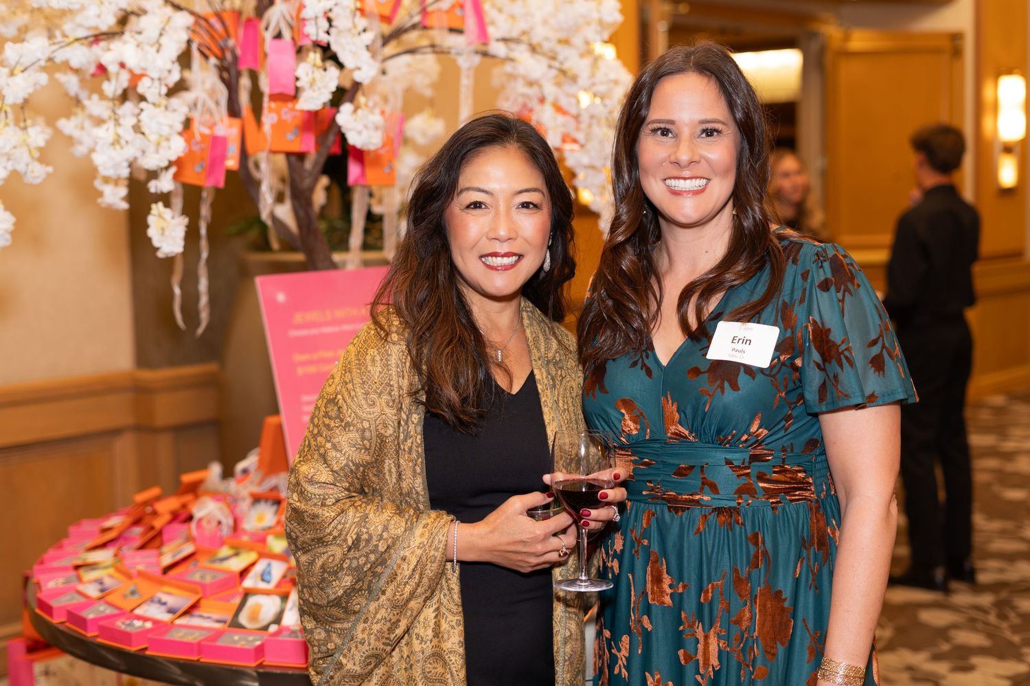 Guests mingling at an indoor social event with warm lighting and formal attire.