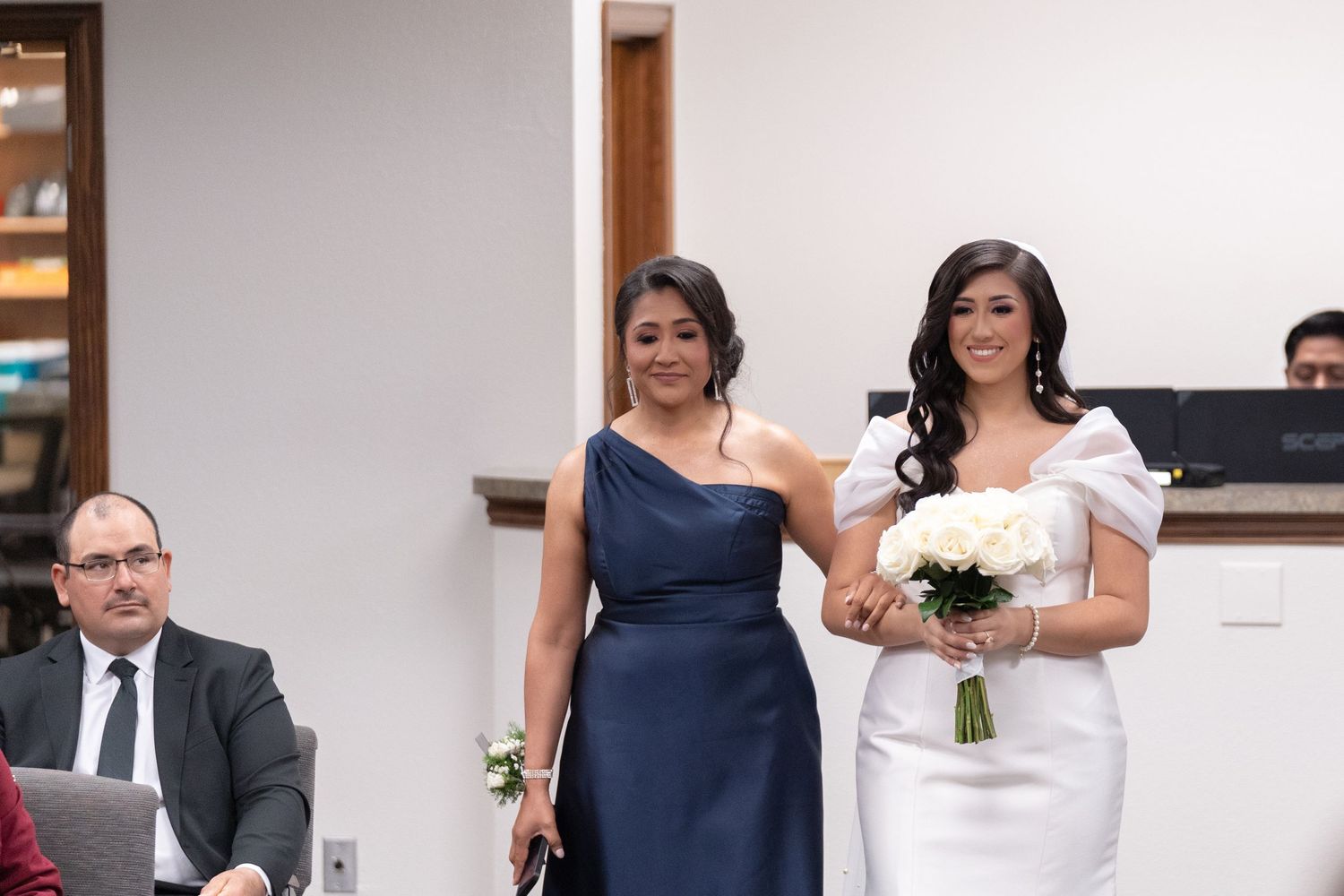 Wedding party in navy blue and white attire poses together for formal photos during celebration.
