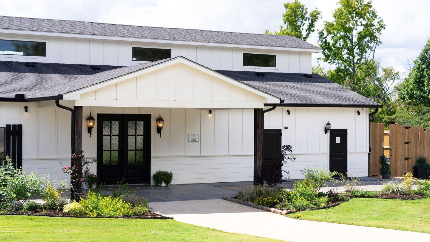 Modern white ranch-style house with attached garage and well-maintained green lawn on a sunny day.
