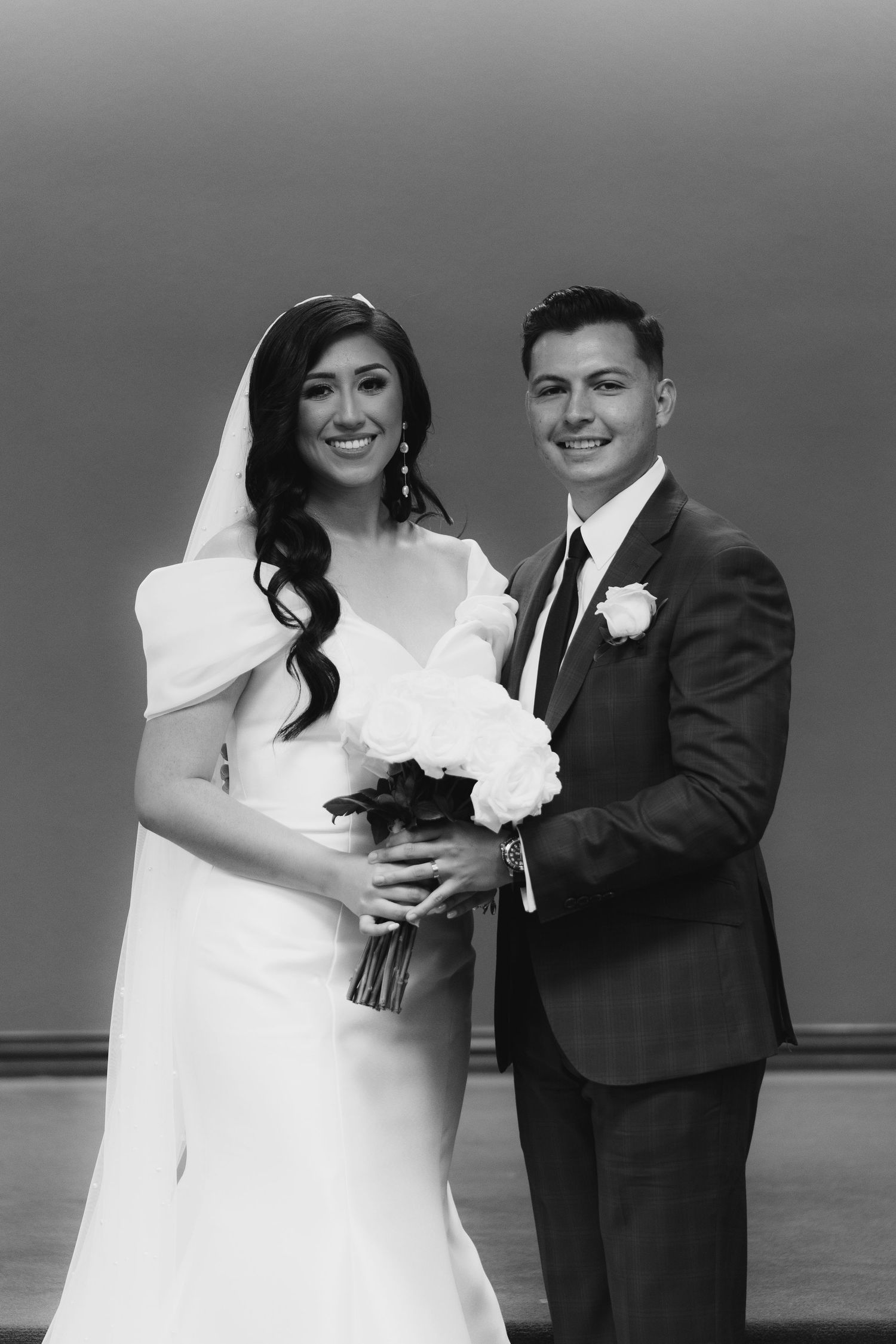 Black and white wedding photo series showing a couple posing together by the ocean in formal attire.