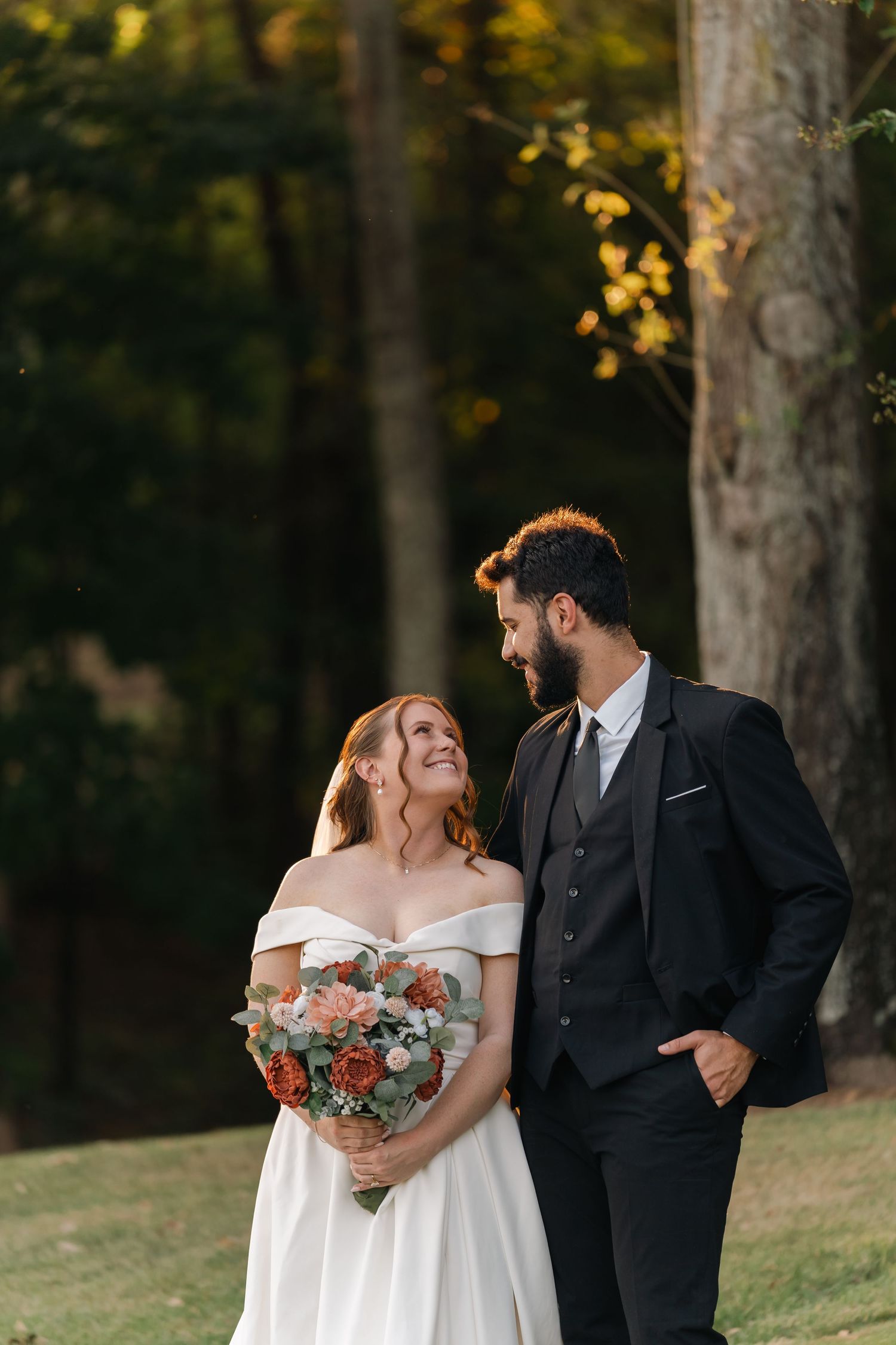 A romantic wedding photo series showing a couple in formal attire sharing joyful moments among autumn trees.