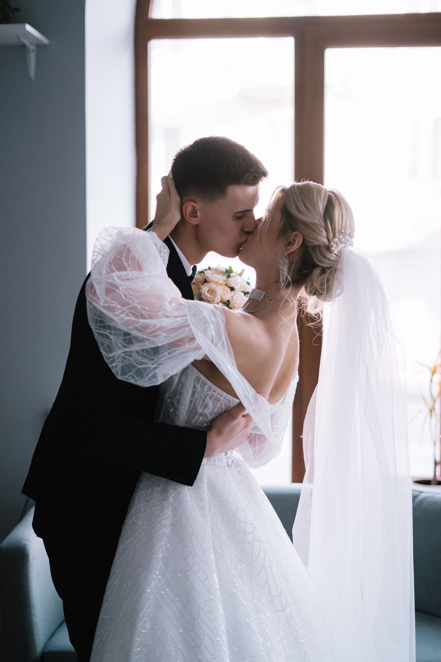 A romantic sequence of wedding photos showing tender moments between newlyweds sharing kisses under a delicate veil.
