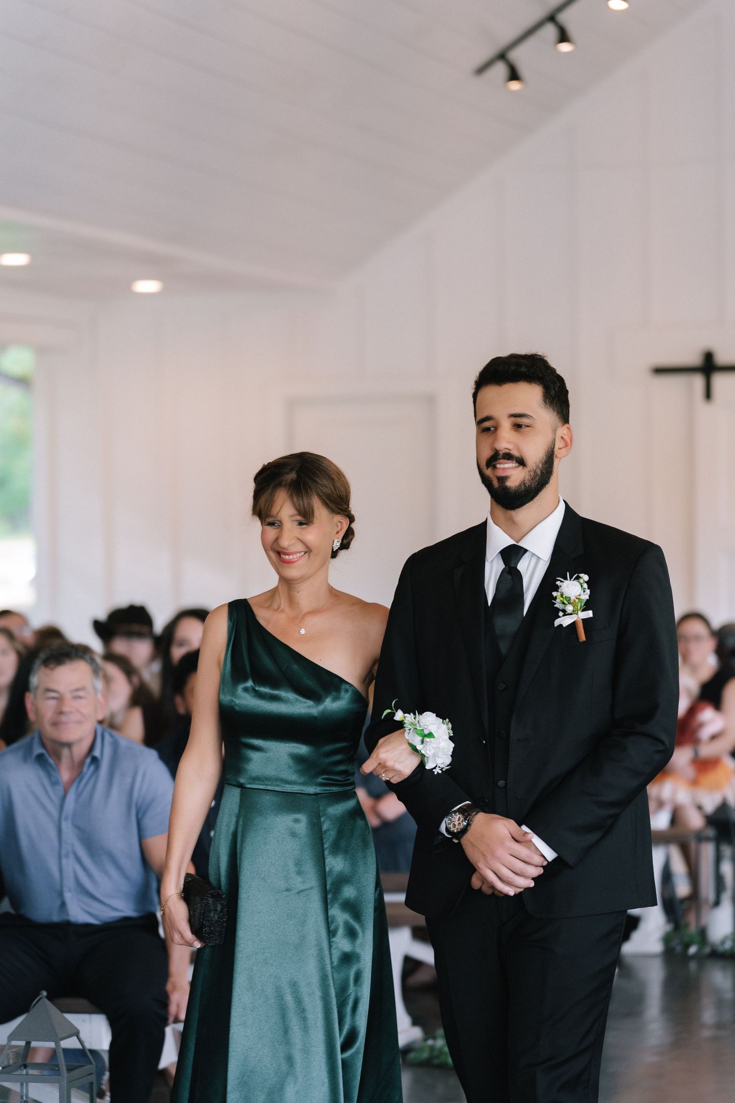A wedding ceremony processional with attendants walking down the aisle in elegant attire.