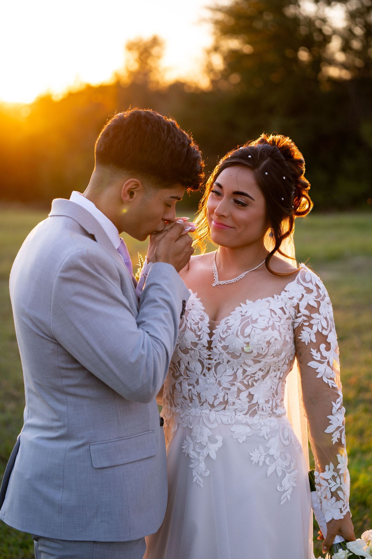 A tender moment between newlyweds during golden hour in an outdoor setting.
