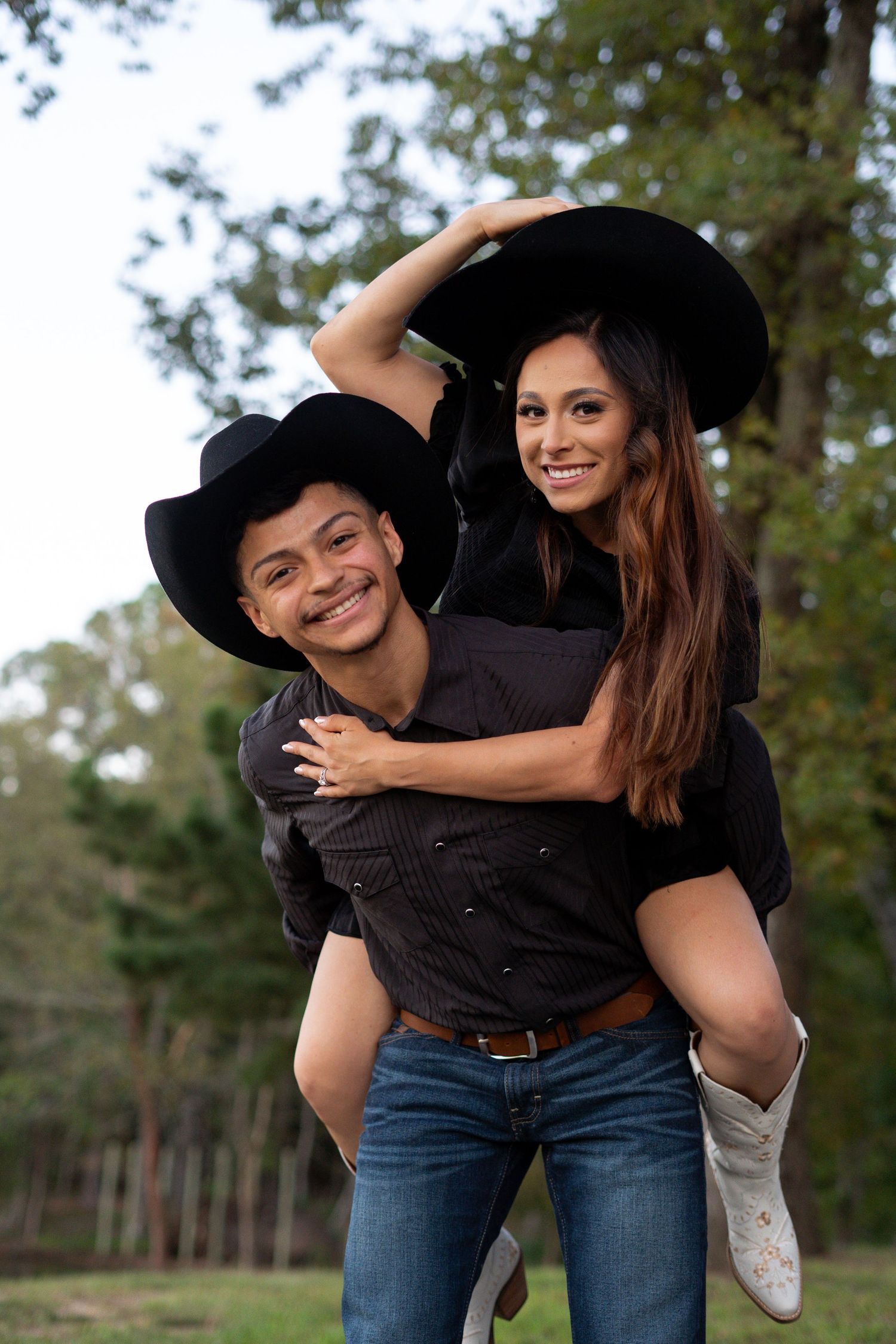 A playful couple embraces outdoors wearing black cowboy hats and casual attire in a series of candid shots.