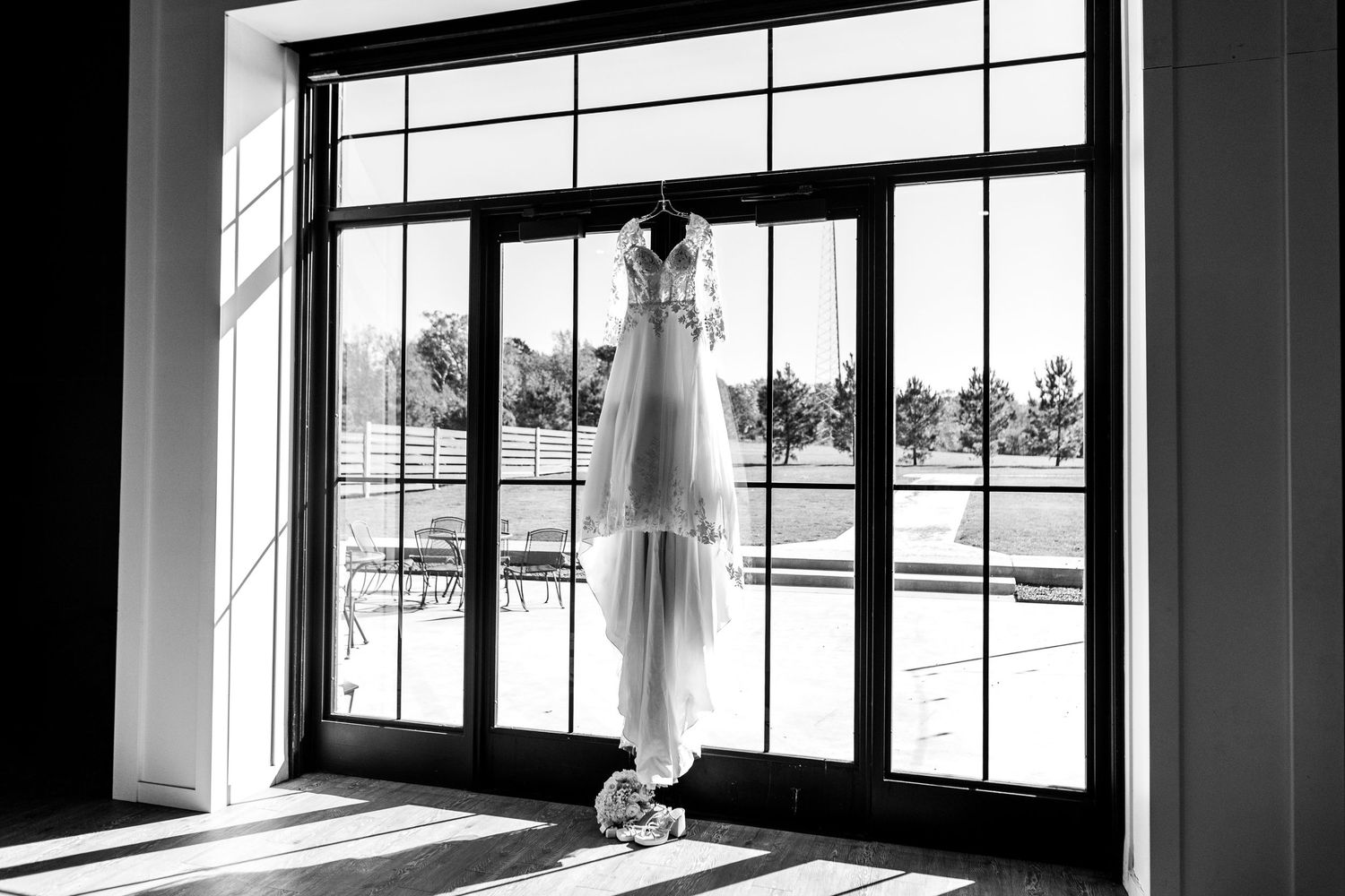 Black and white panoramic view of a modern interior space with large windows and natural lighting.
