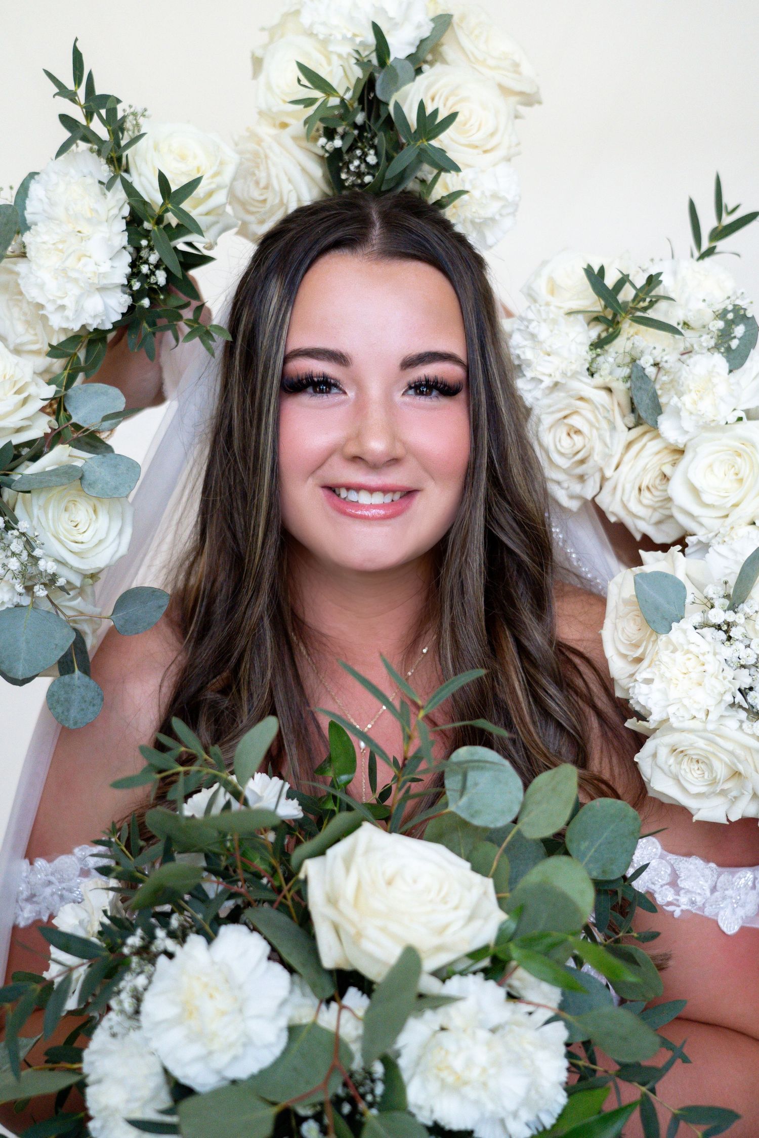 Beautiful white roses and eucalyptus greenery create an elegant floral arrangement against a soft background.
