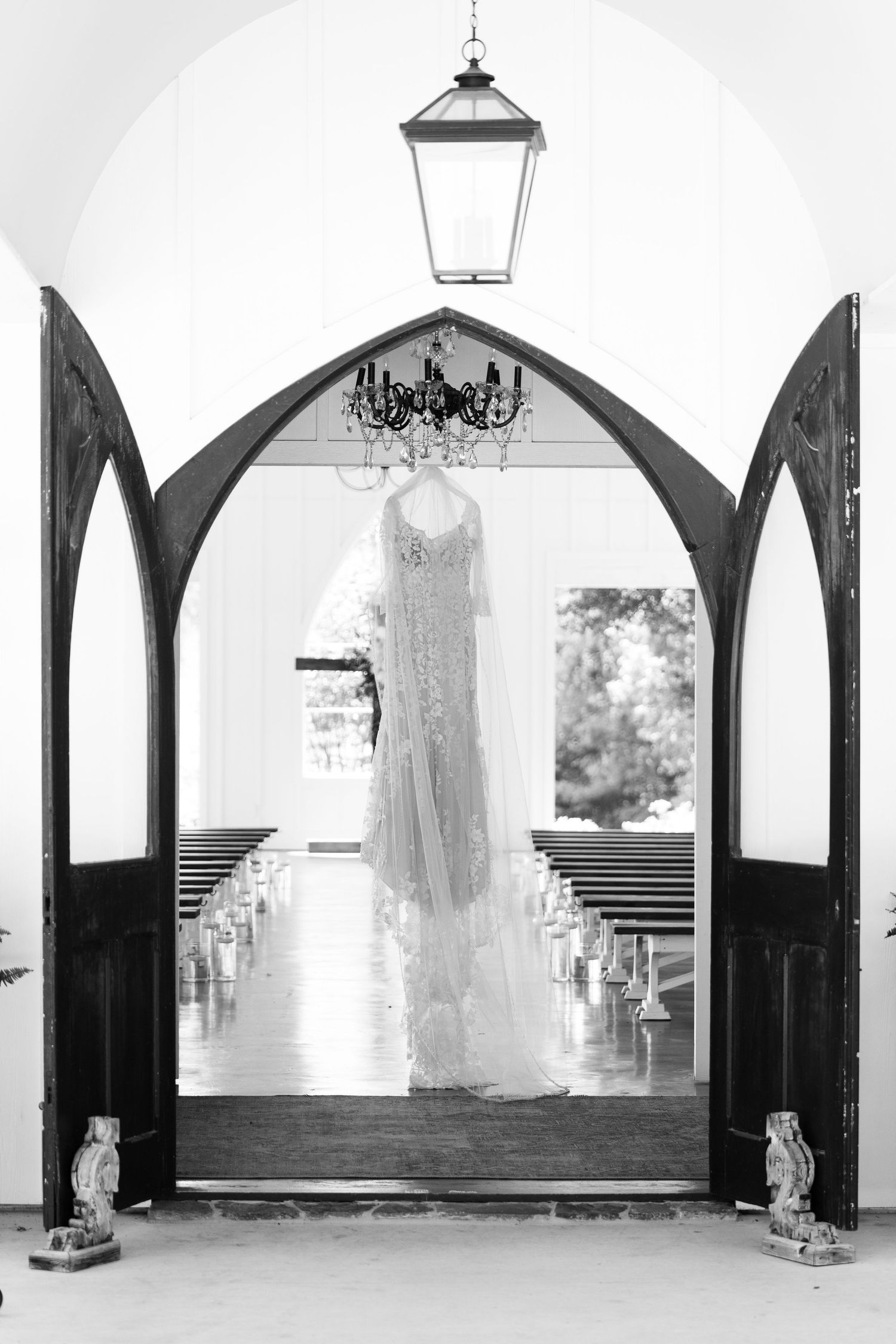 Four black and white photos showing elegant wedding dresses hanging in arched church doorways.