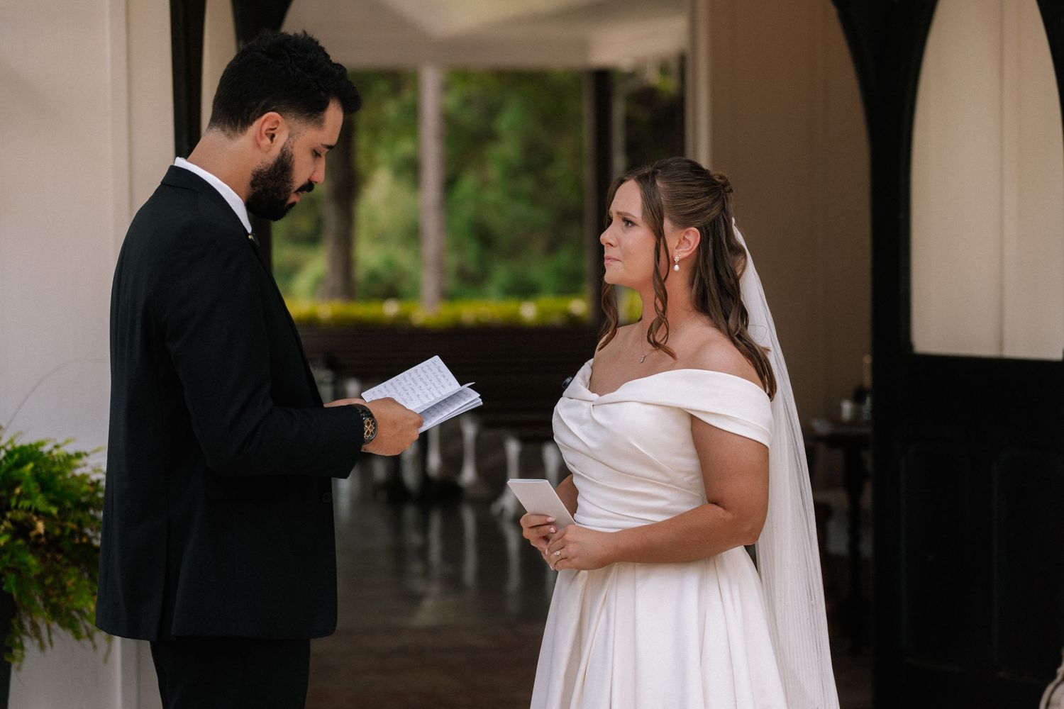 Couple reading vows during an intimate outdoor wedding ceremony.