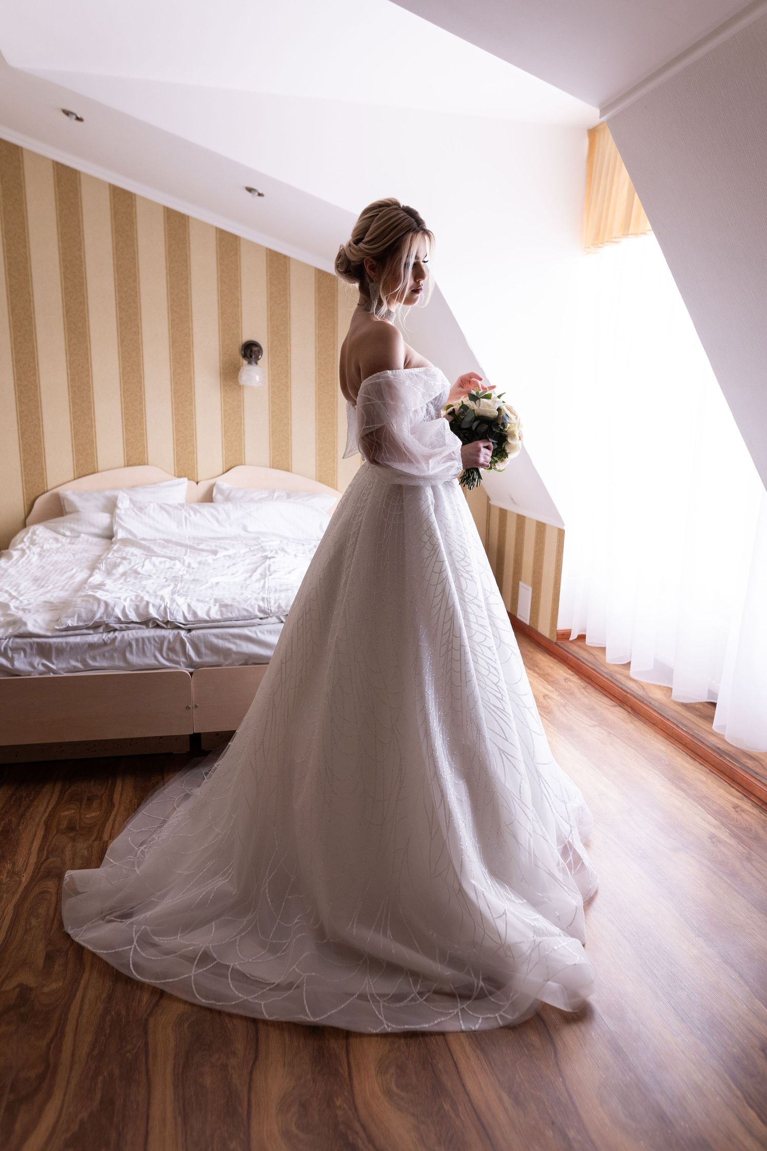 A stunning white wedding dress with a flowing train and lace details shown in a series of elegant bridal portraits.
