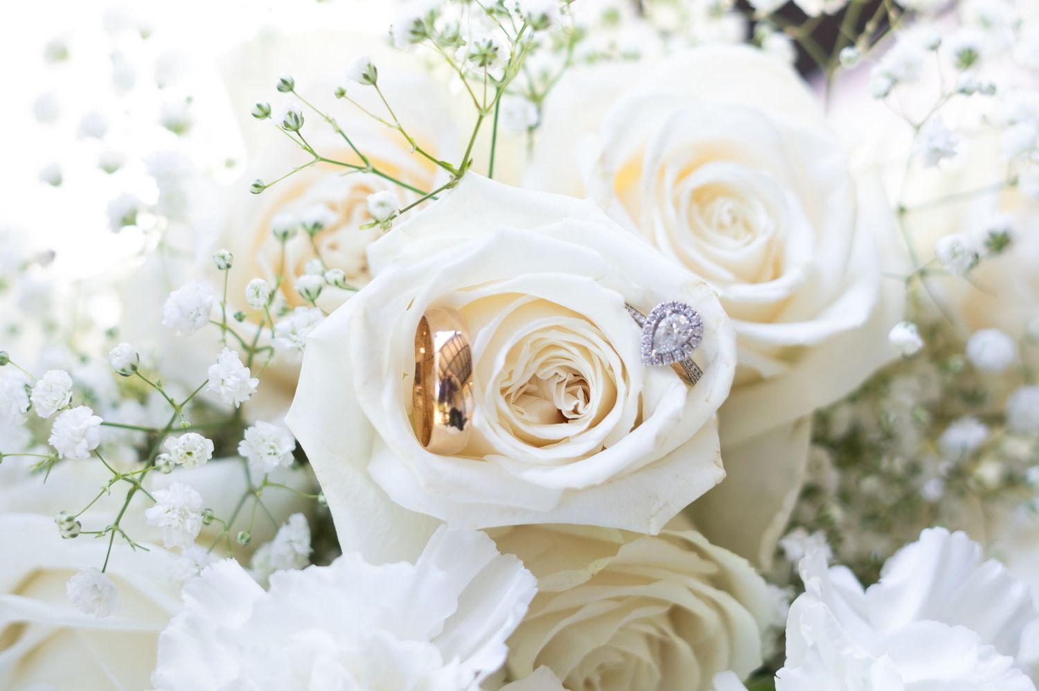 Delicate white roses and baby's breath flowers arranged in an elegant wedding bouquet display.
