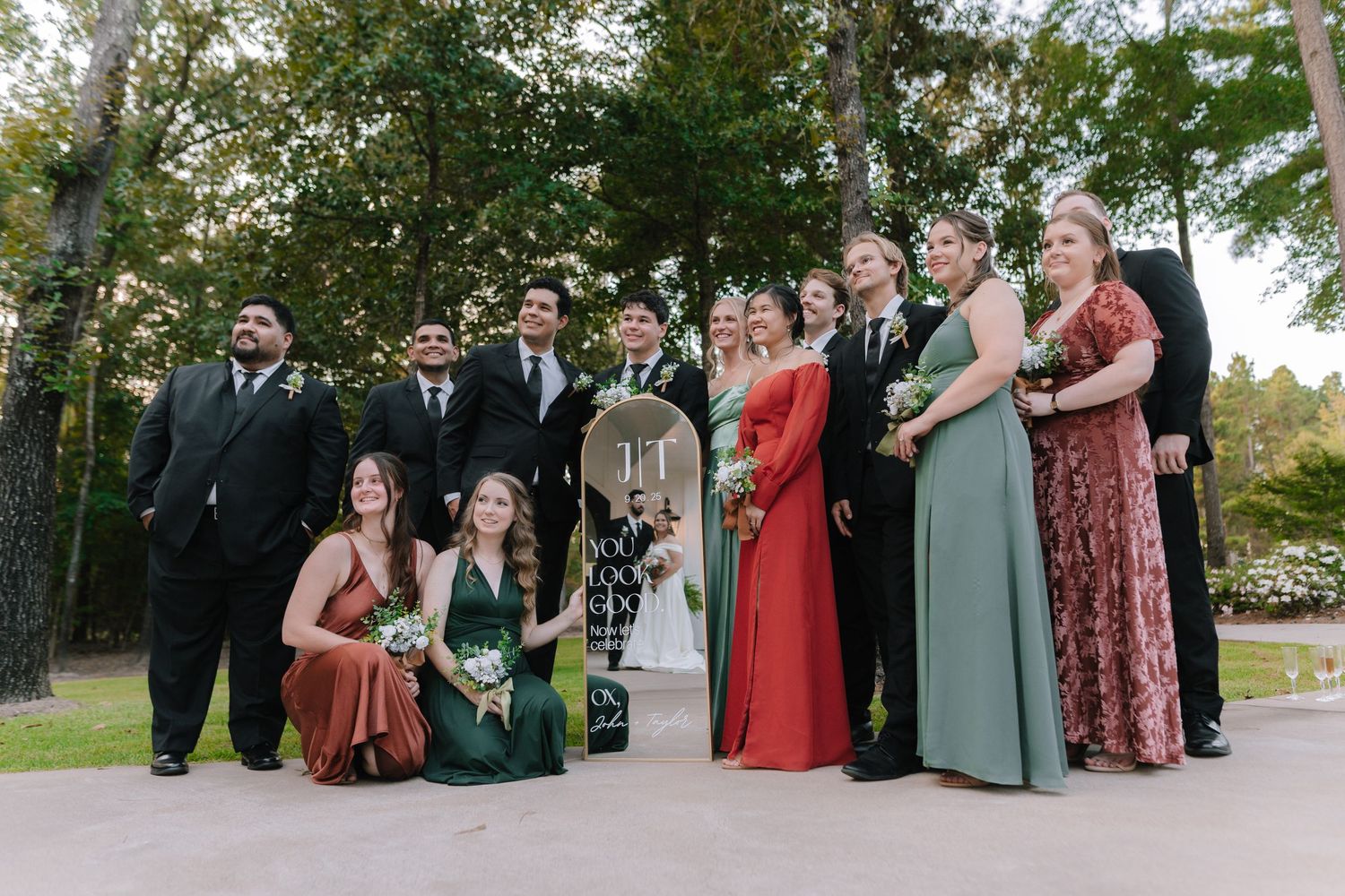 Wedding guests seated outdoors in rows of chairs during a garden ceremony.
