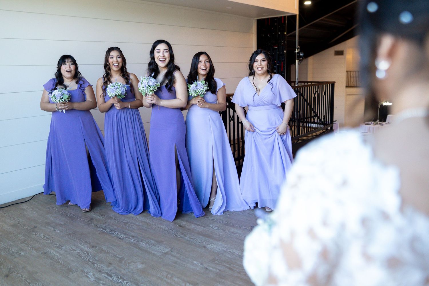 Group photo of bridesmaids in matching periwinkle gowns sitting together.