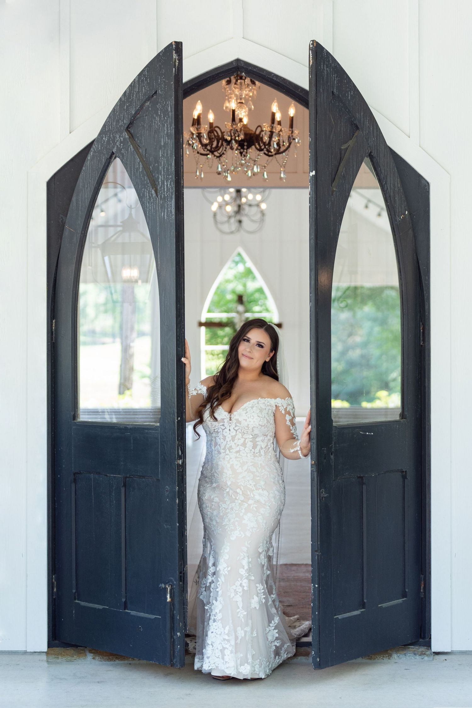 A bridal portrait session featuring elegant poses against navy blue arched doors and white walls in a classic venue setting.