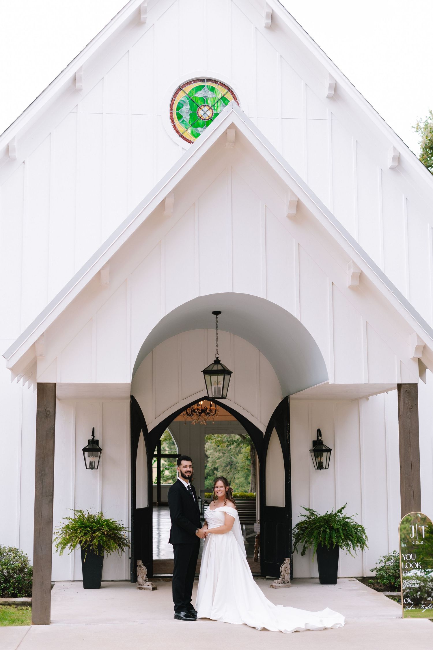 White chapel exterior with gothic arches and hanging lanterns creates an elegant wedding venue backdrop.
