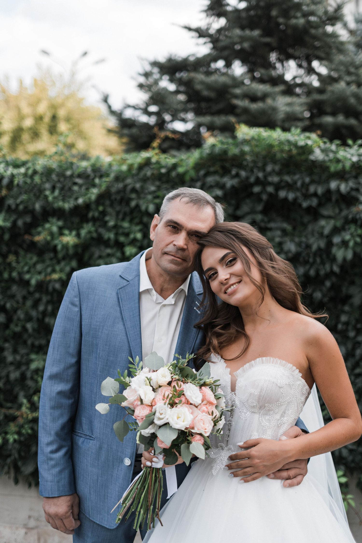 A romantic outdoor wedding photoshoot featuring a couple with a beautiful floral bouquet.
