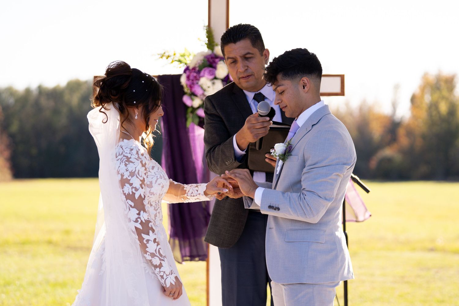 Outdoor wedding ceremony scene with guests gathered in golden afternoon light.