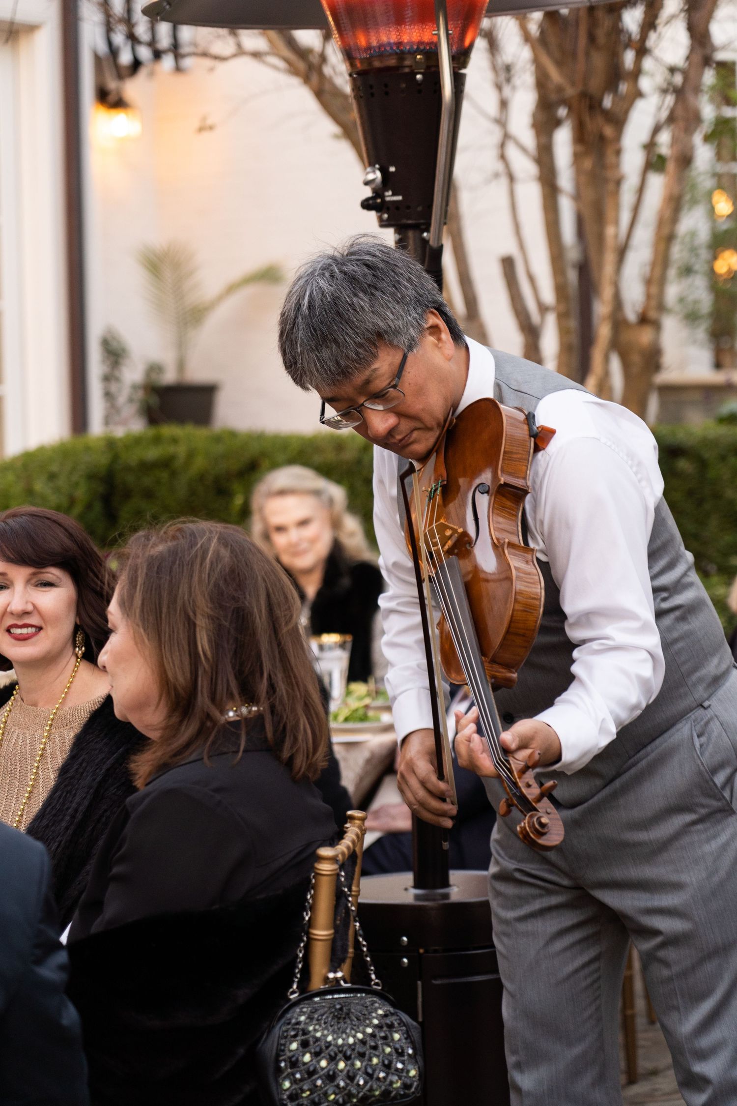 Violinist performs for guests during elegant evening gathering.