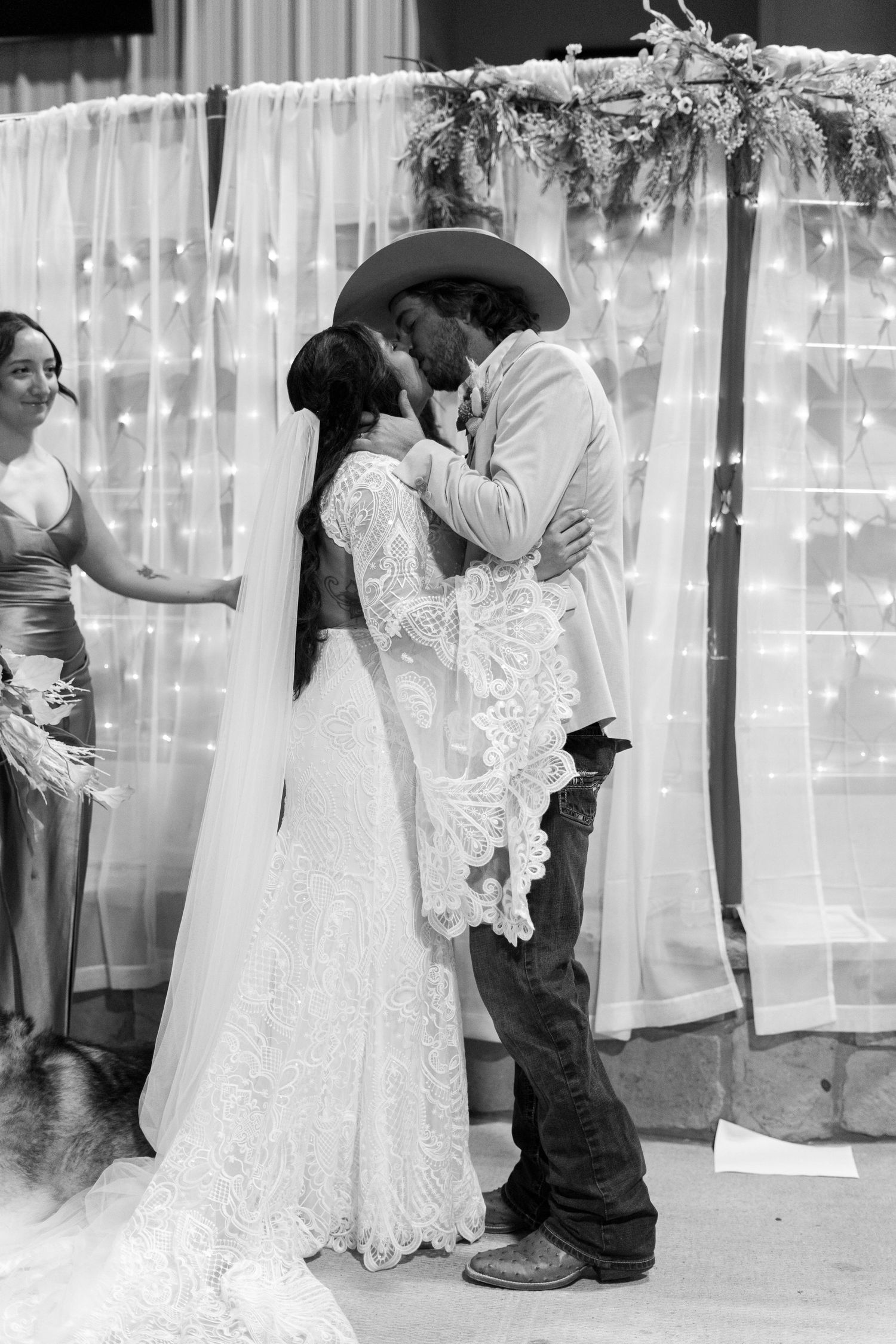A romantic wedding ceremony moment under twinkling lights and greenery.