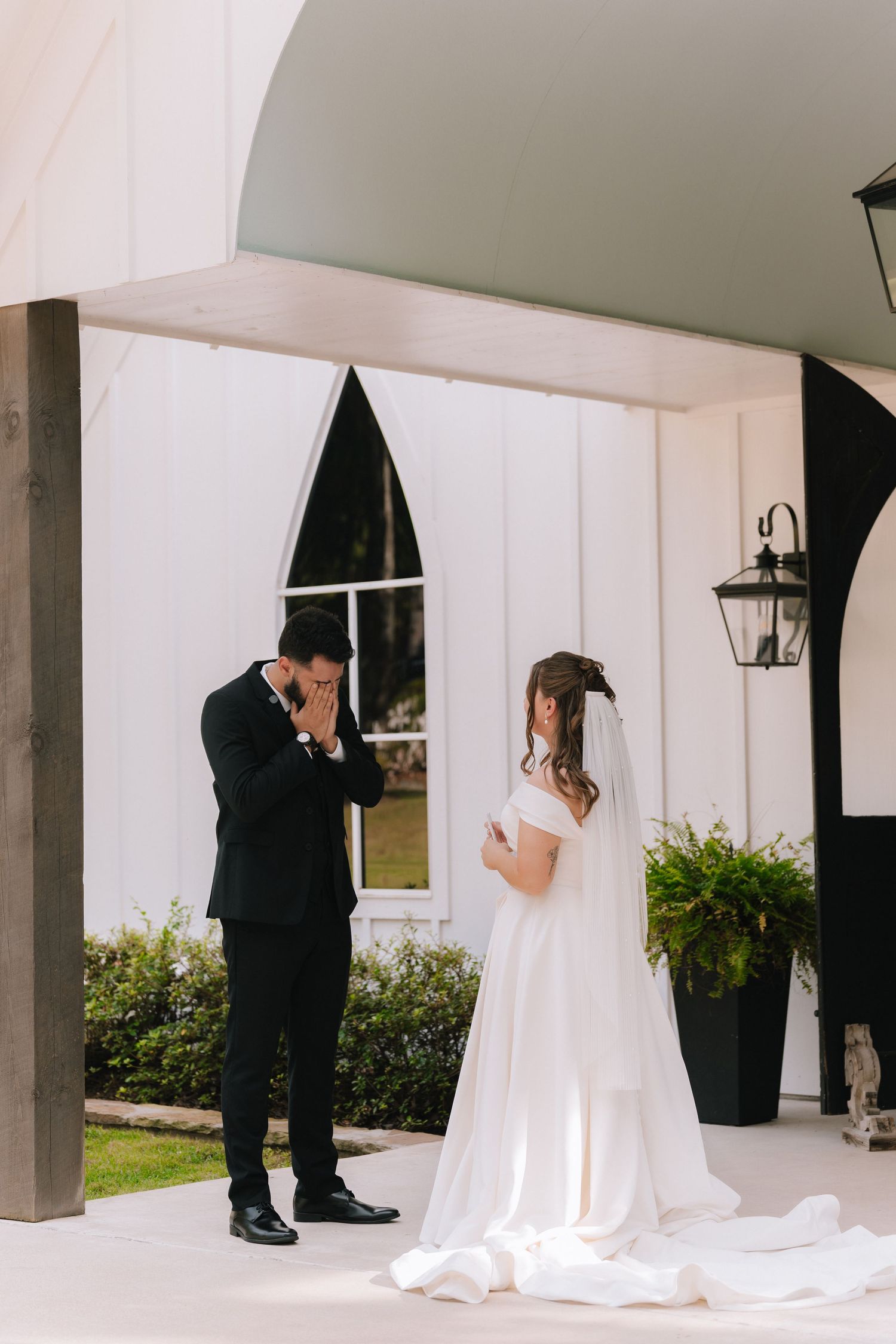 A series of intimate first look photos between a couple under a white chapel portico.