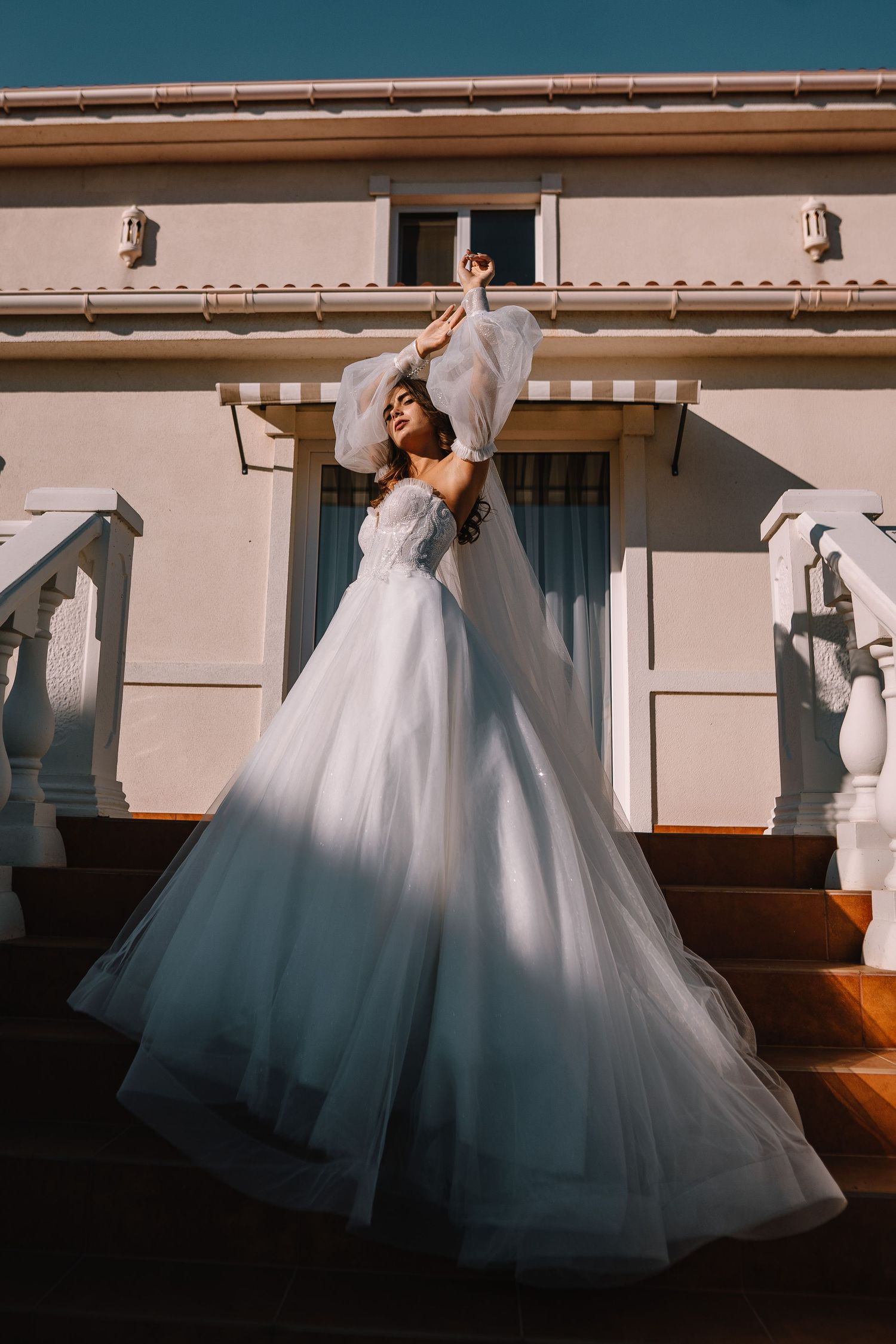 A sequence of dance movements showing the flowing motion of a white wedding gown against a light colored wall.