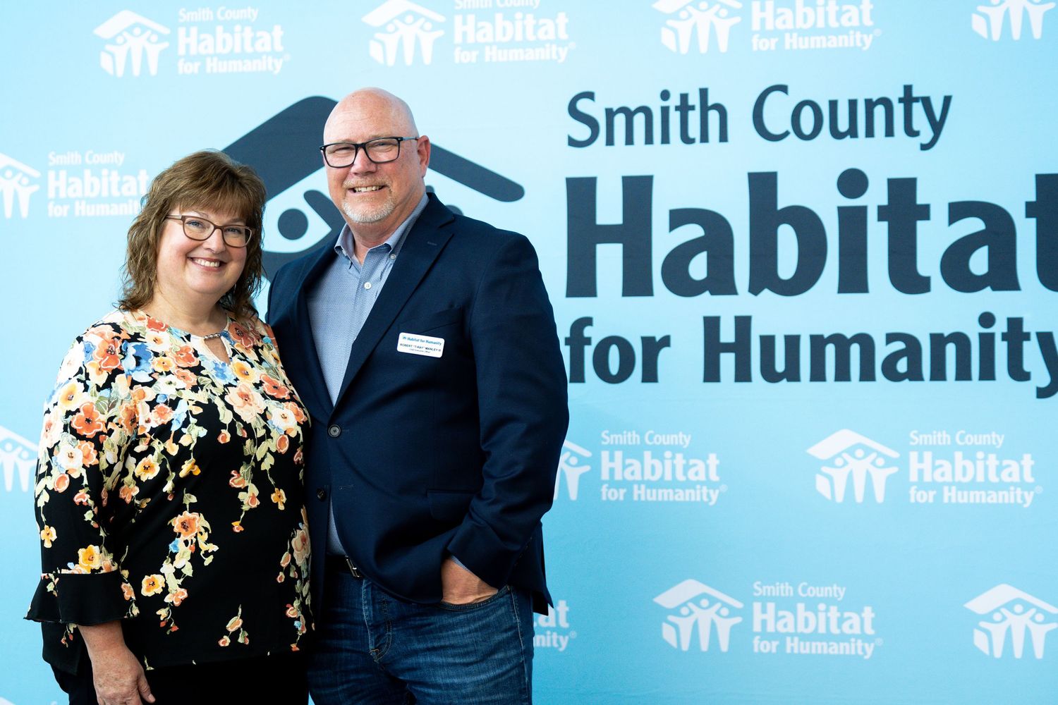 Habitat for Humanity Smith County event with blue branded backdrop.