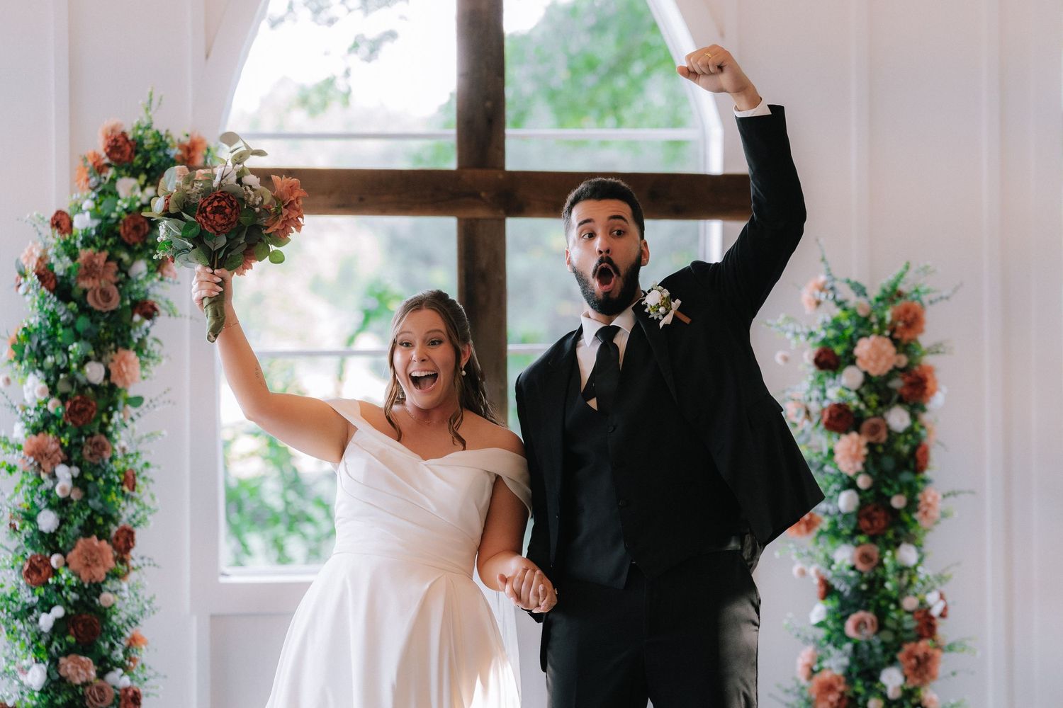 Celebratory moment during wedding ceremony with floral decorations.