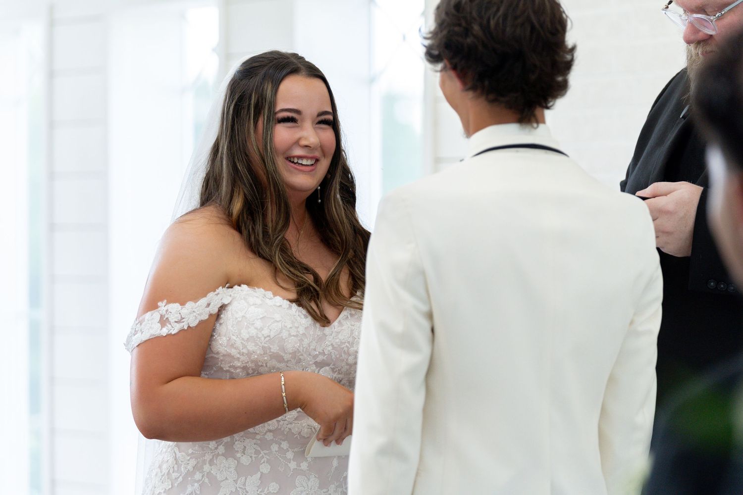 A couple shares a romantic first dance moment at their wedding reception while guests look on.