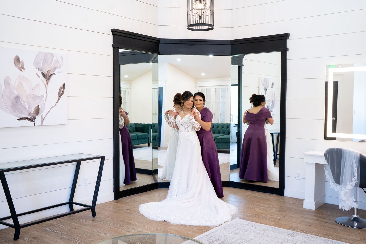 Modern bridal suite with white walls and black trim features multiple mirrors for wedding preparation.