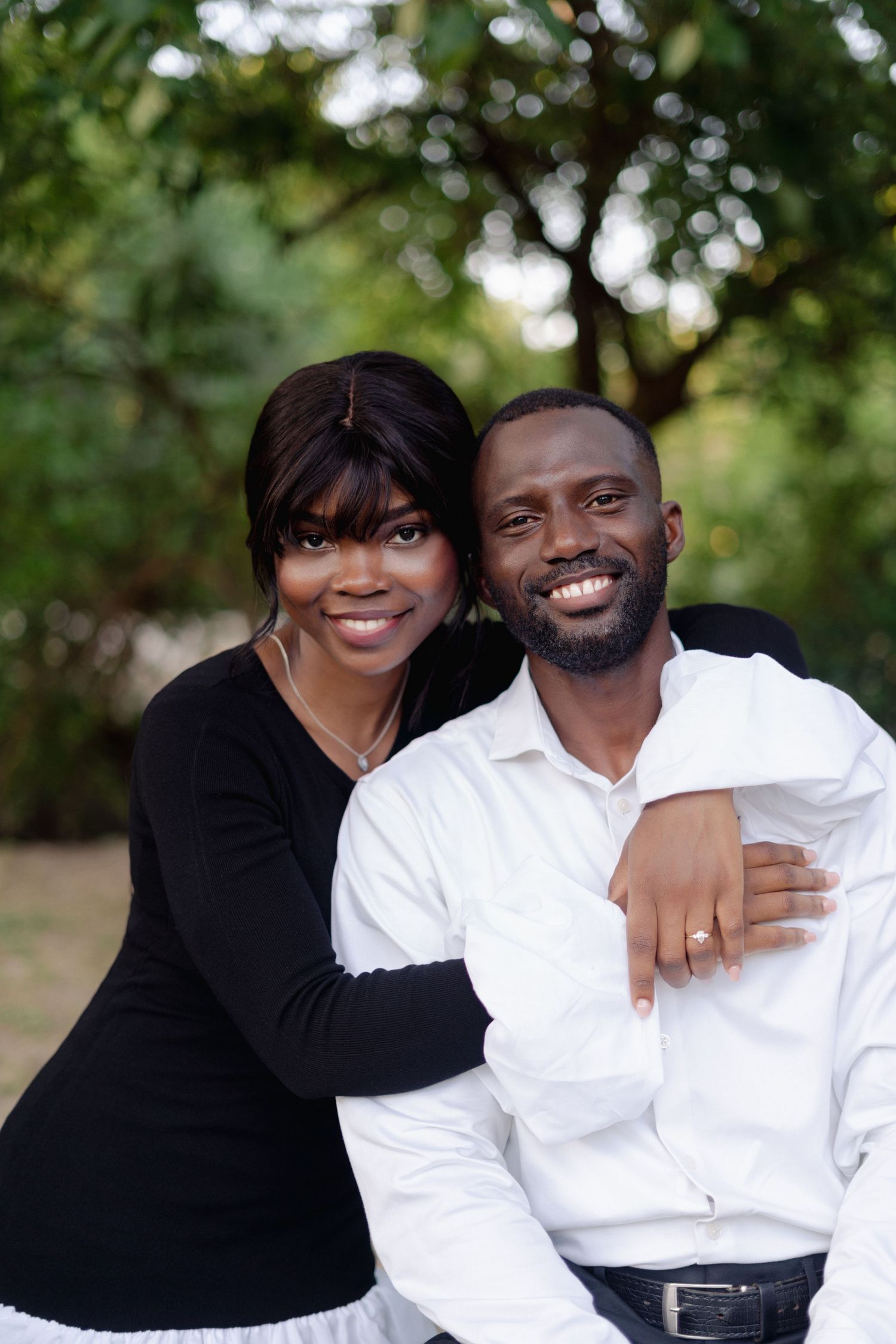 Couple in black and white outfits sharing affectionate moments outdoors.