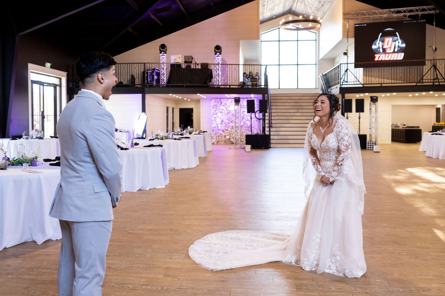 Spacious wedding venue interior with white decor and natural lighting.