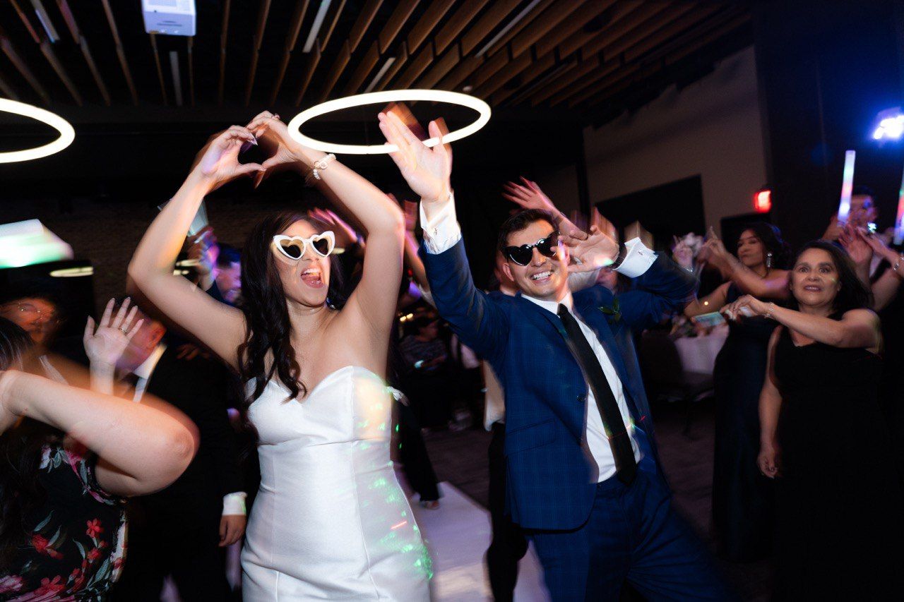 Wedding reception party scene with guests dancing under circular lights.