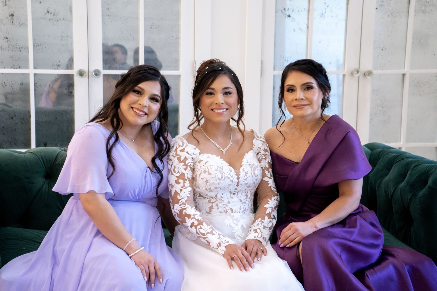 Candid moment of wedding party relaxing on vintage furniture in shades of purple.