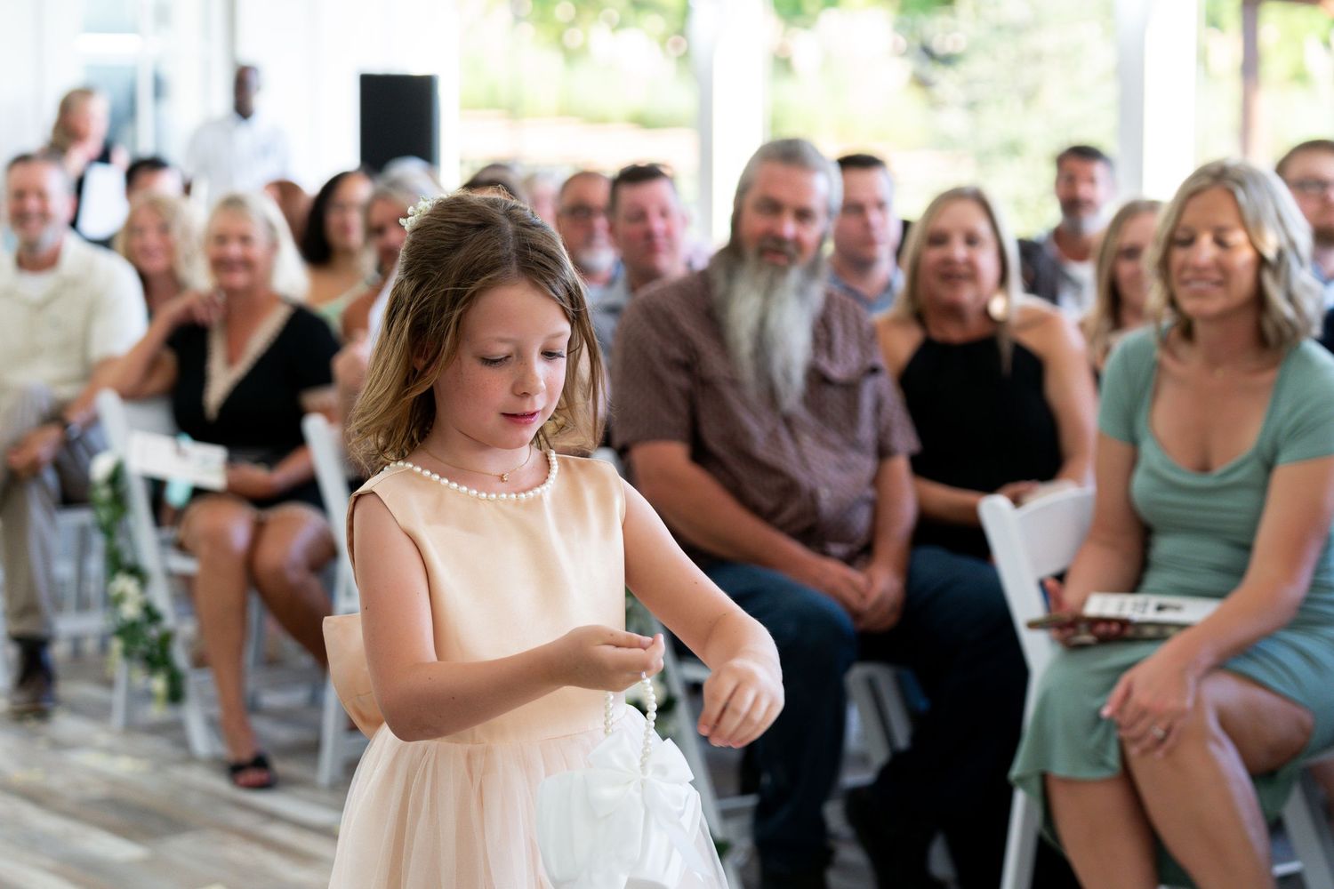 Wedding guests mingle and socialize at an elegant reception with white tablecloths and floral centerpieces.