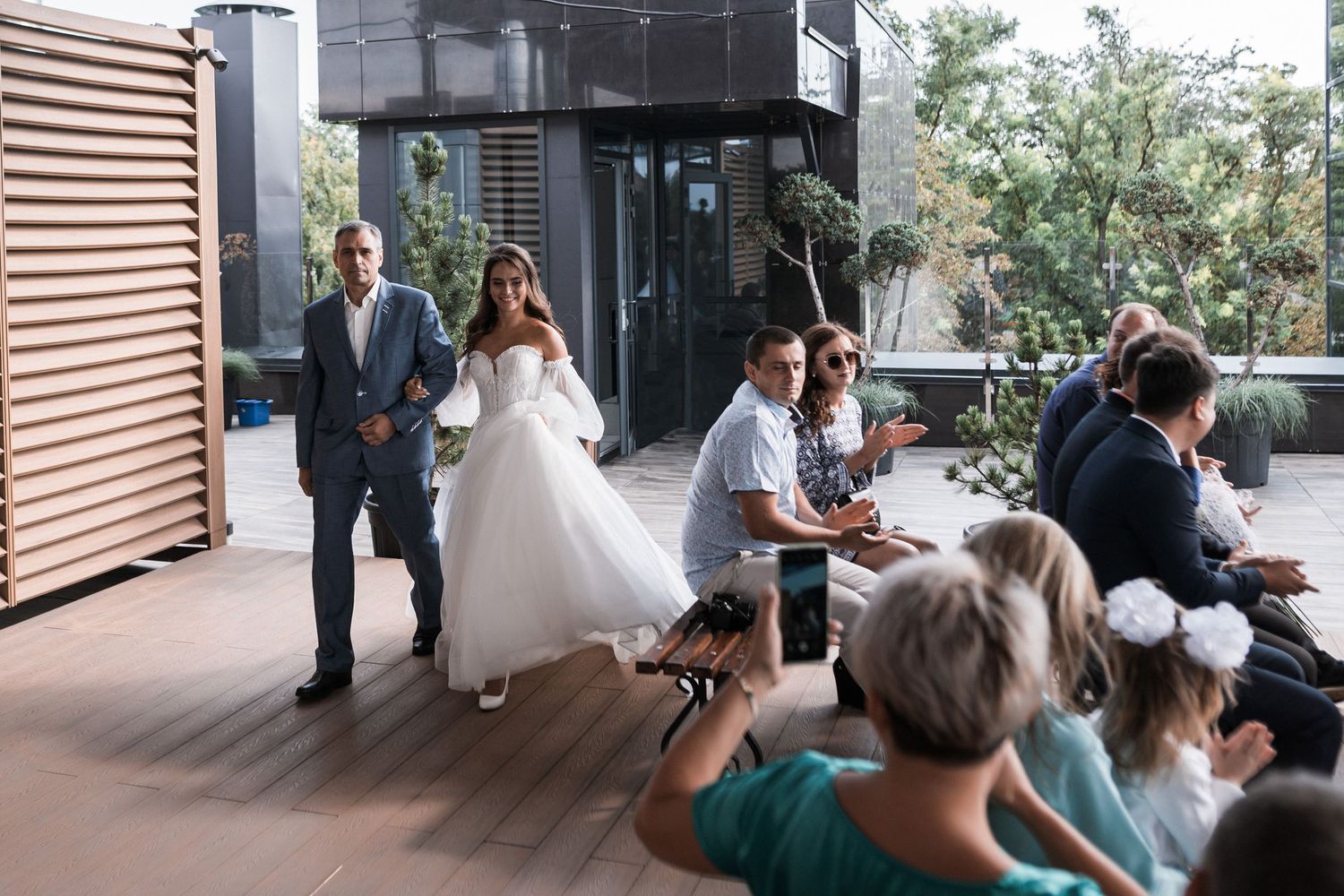 A series of candid moments captured at an outdoor wedding venue with guests and a bride in white dress.