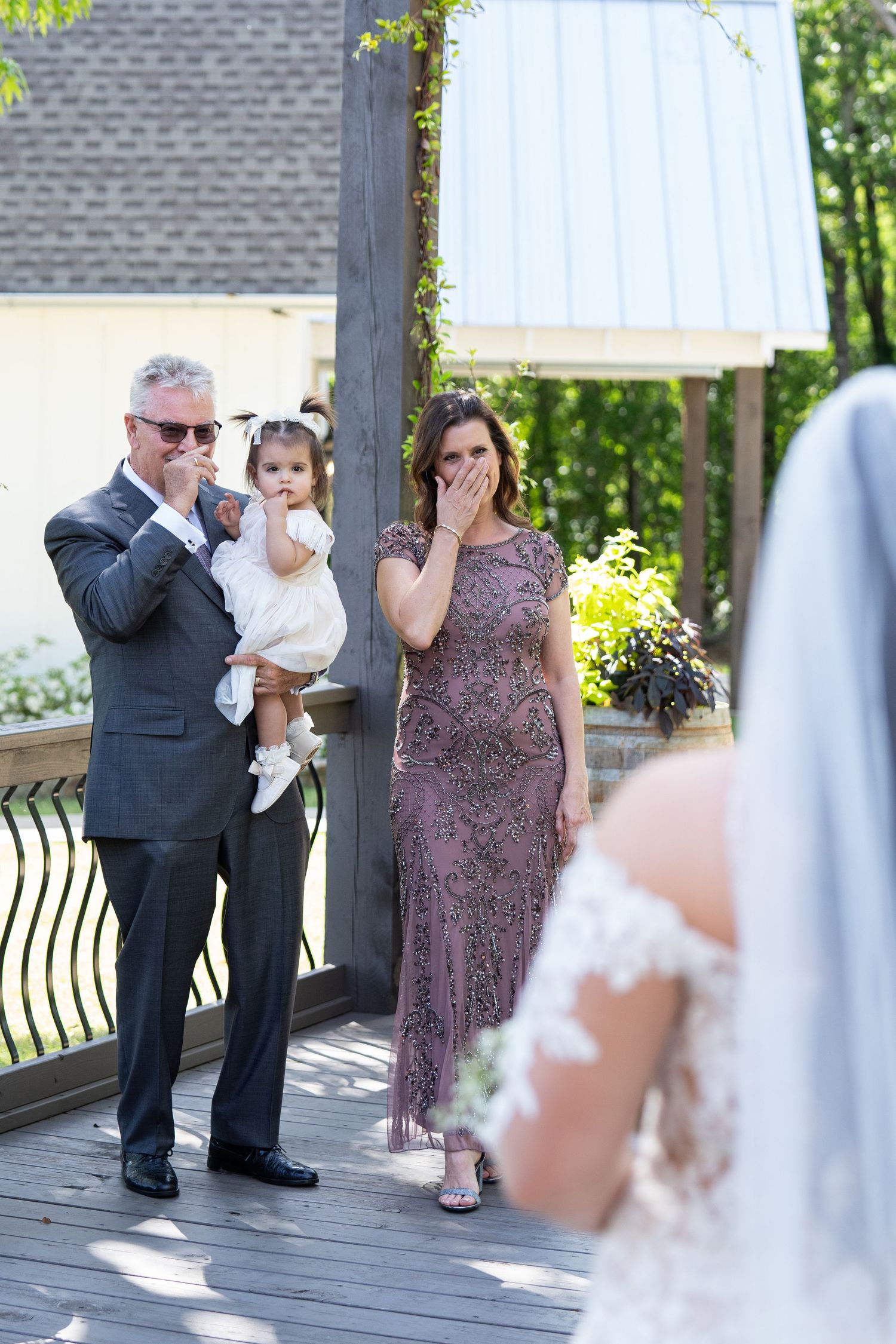 Wedding guests dance and celebrate together on an outdoor patio during a reception celebration.