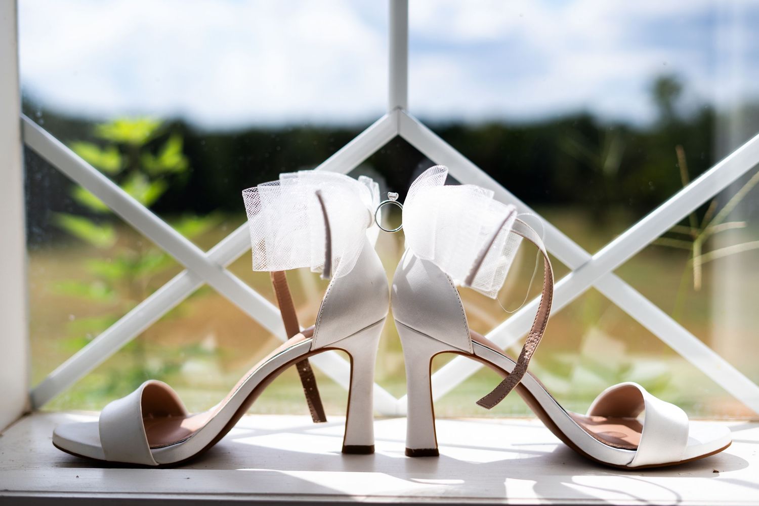 White satin bridal heels with delicate ankle straps and peep toe design displayed in multiple angles.