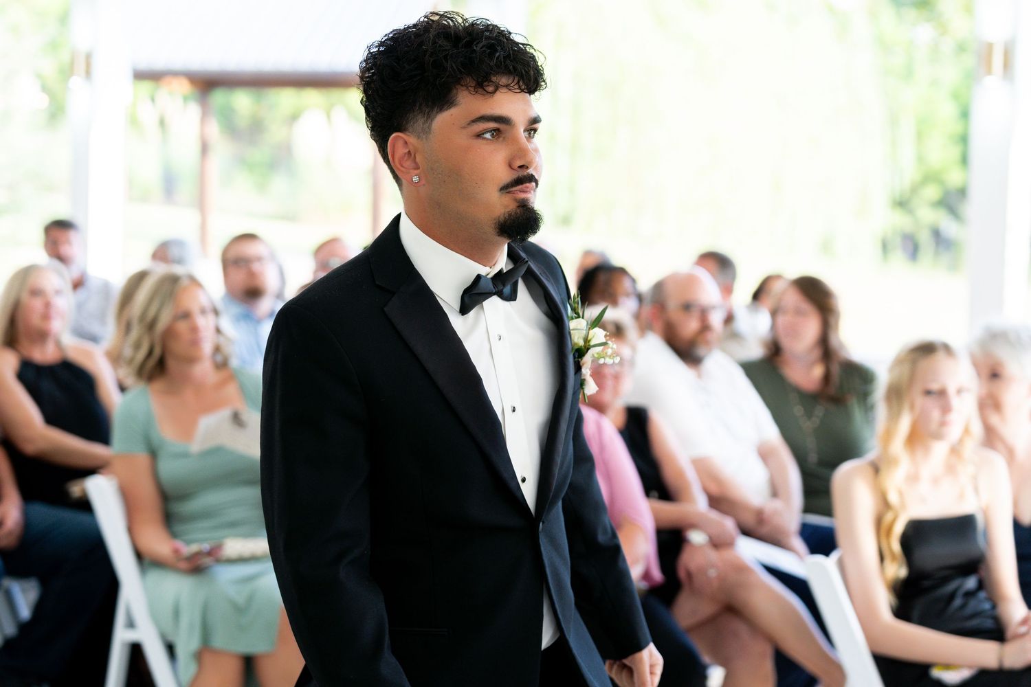 A formal wedding reception with guests seated at tables in an elegant indoor setting.