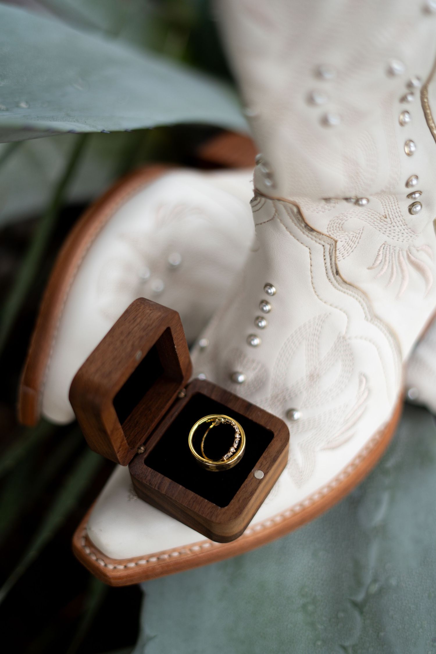 Close-up sequence of a wooden ring box opening to reveal a gold wedding band.