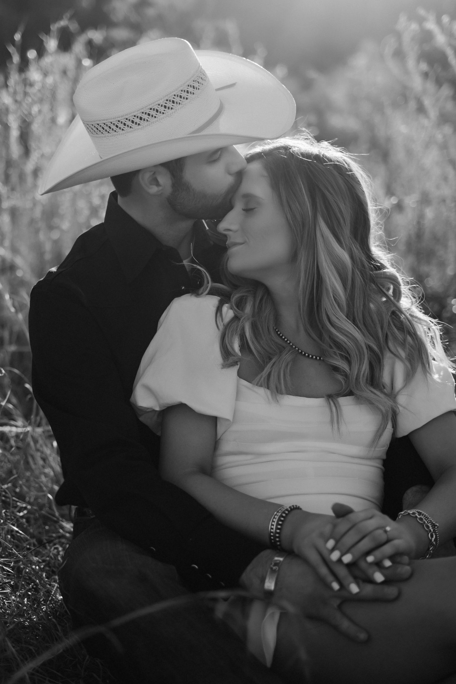 Black and white romantic photos showing tender moments in natural outdoor setting.