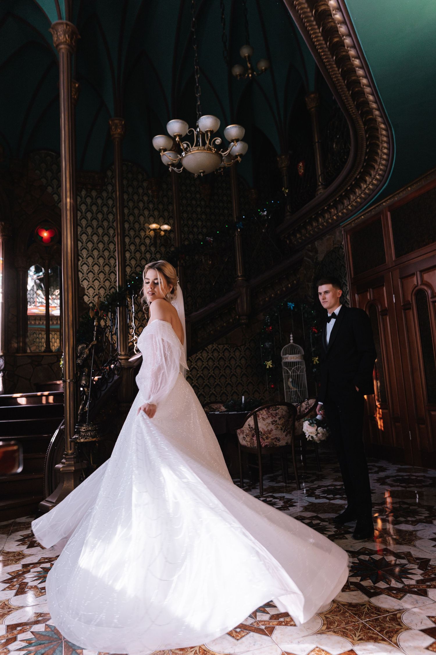 A bride in a flowing white ballgown twirls gracefully across an ornate ballroom floor with dramatic lighting.