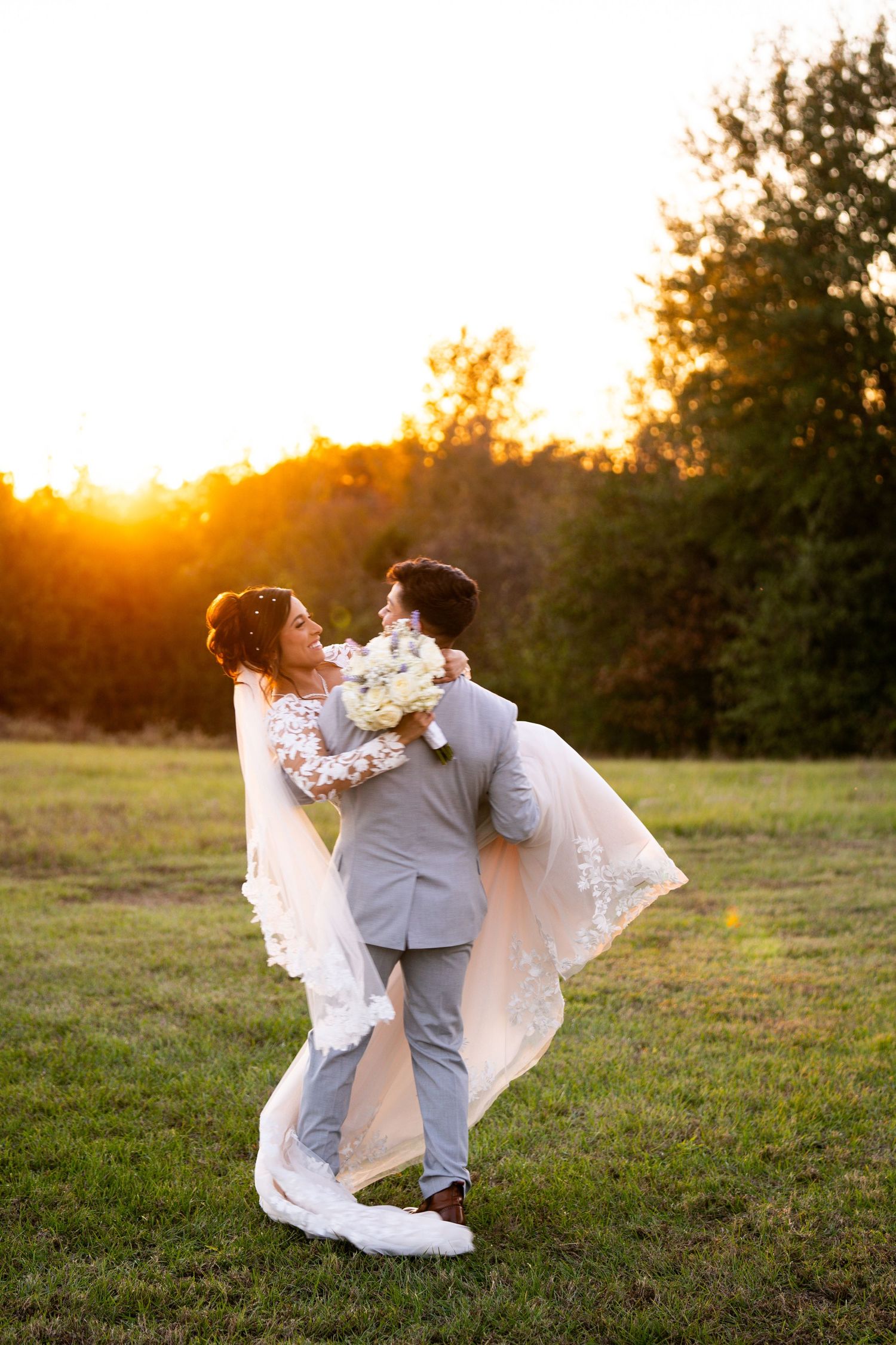Sunset wedding portraits with couple dancing in golden light.