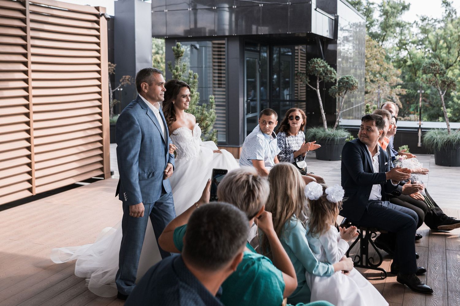 A series of connected images showing guests mingling at an outdoor event on a modern patio space.