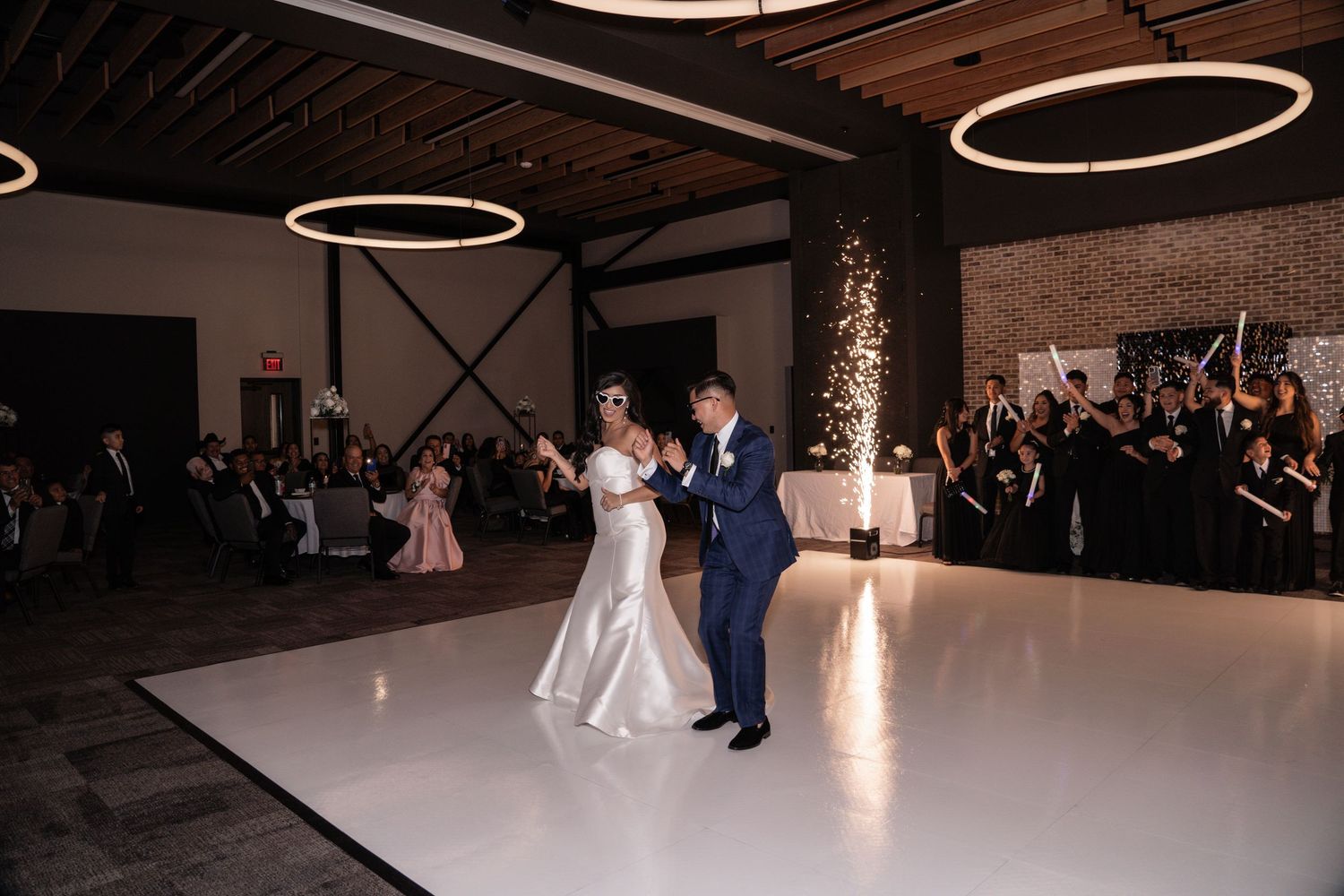 A couple shares their first dance at a wedding reception in an elegant venue with soft lighting and romantic ambiance.