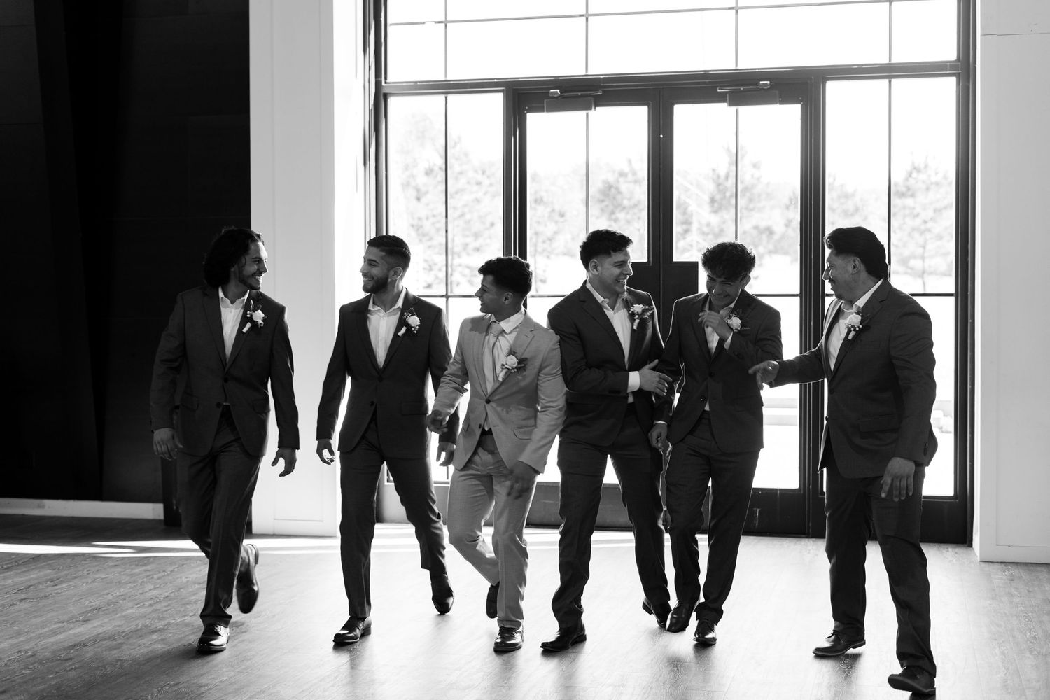 A black and white photo sequence showing a group of people walking in formal attire through an interior space.
