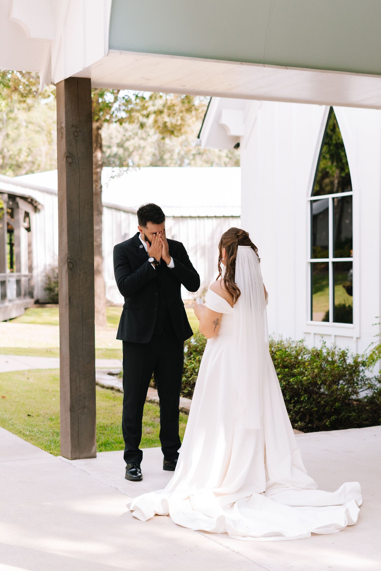 Wedding first look sequence captured under covered walkway with white columns.