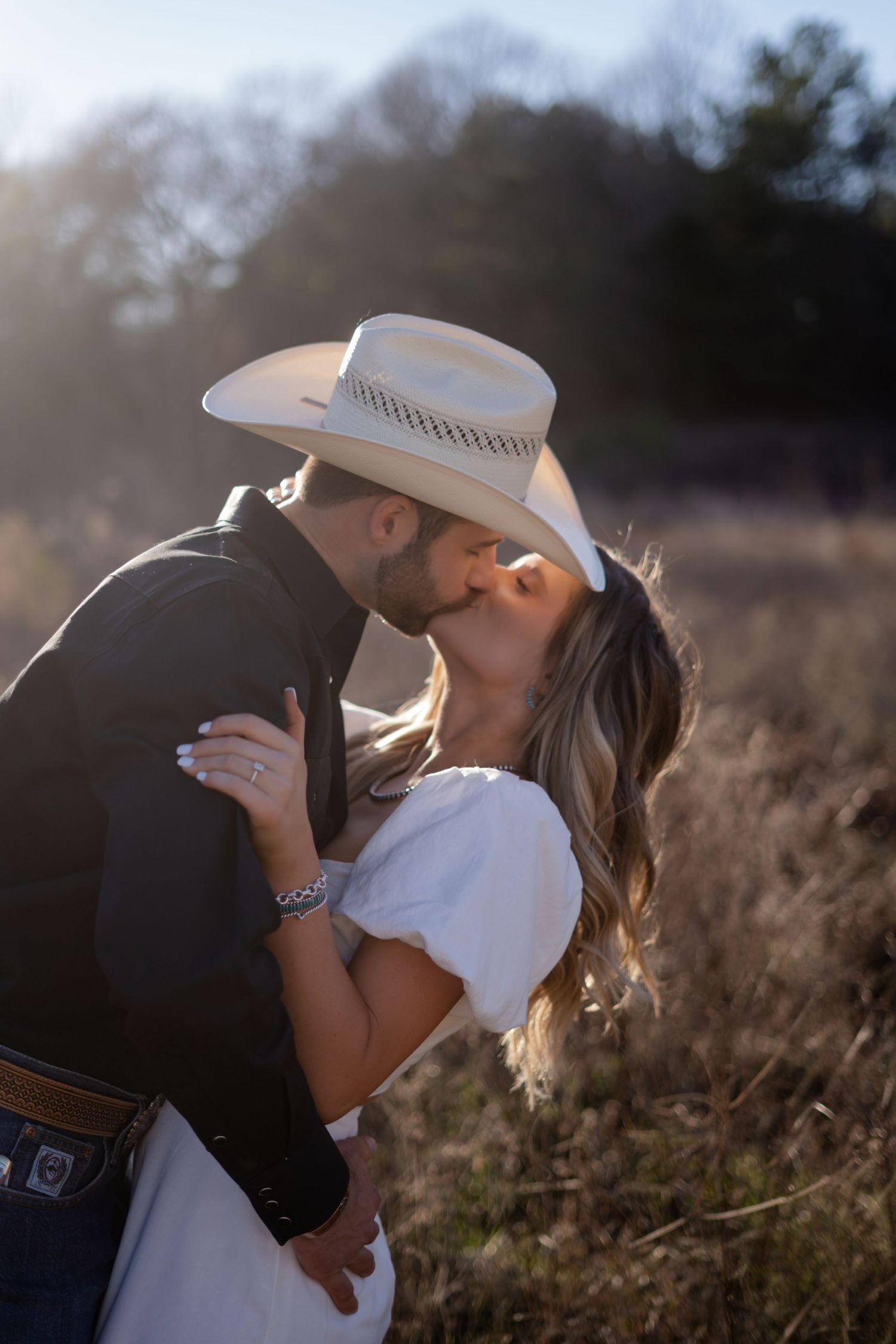 Romantic sunset photoshoot in a field with natural golden lighting.