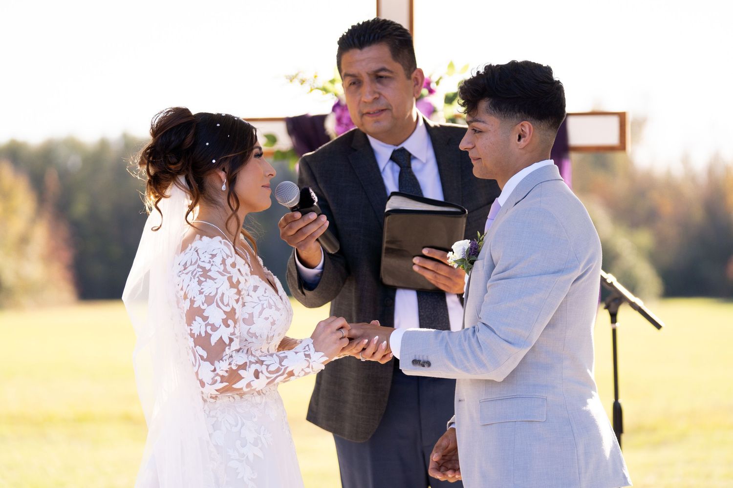Wedding ceremony taking place outdoors with couple exchanging vows.