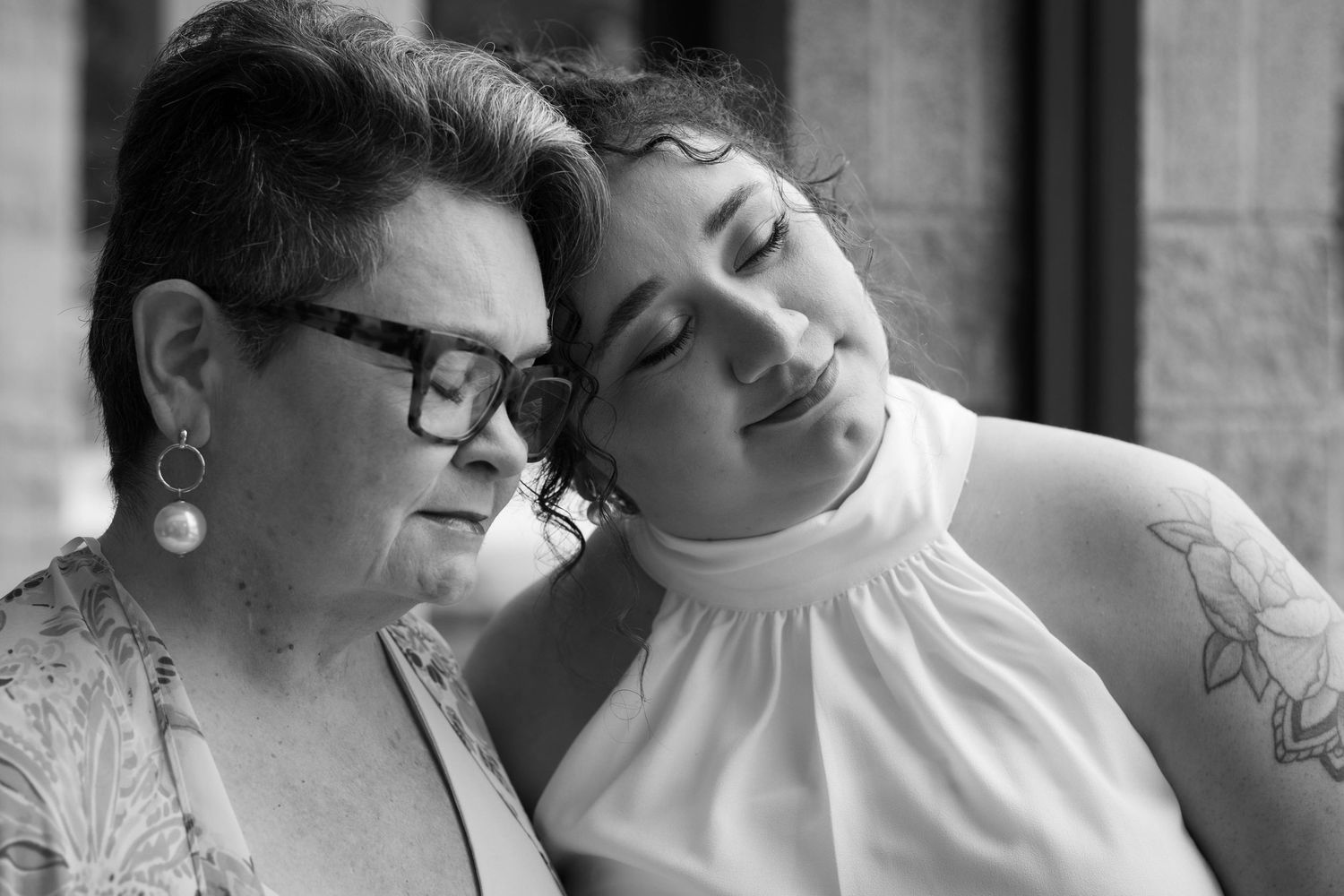 Black and white photo of two women sharing a tender moment together.