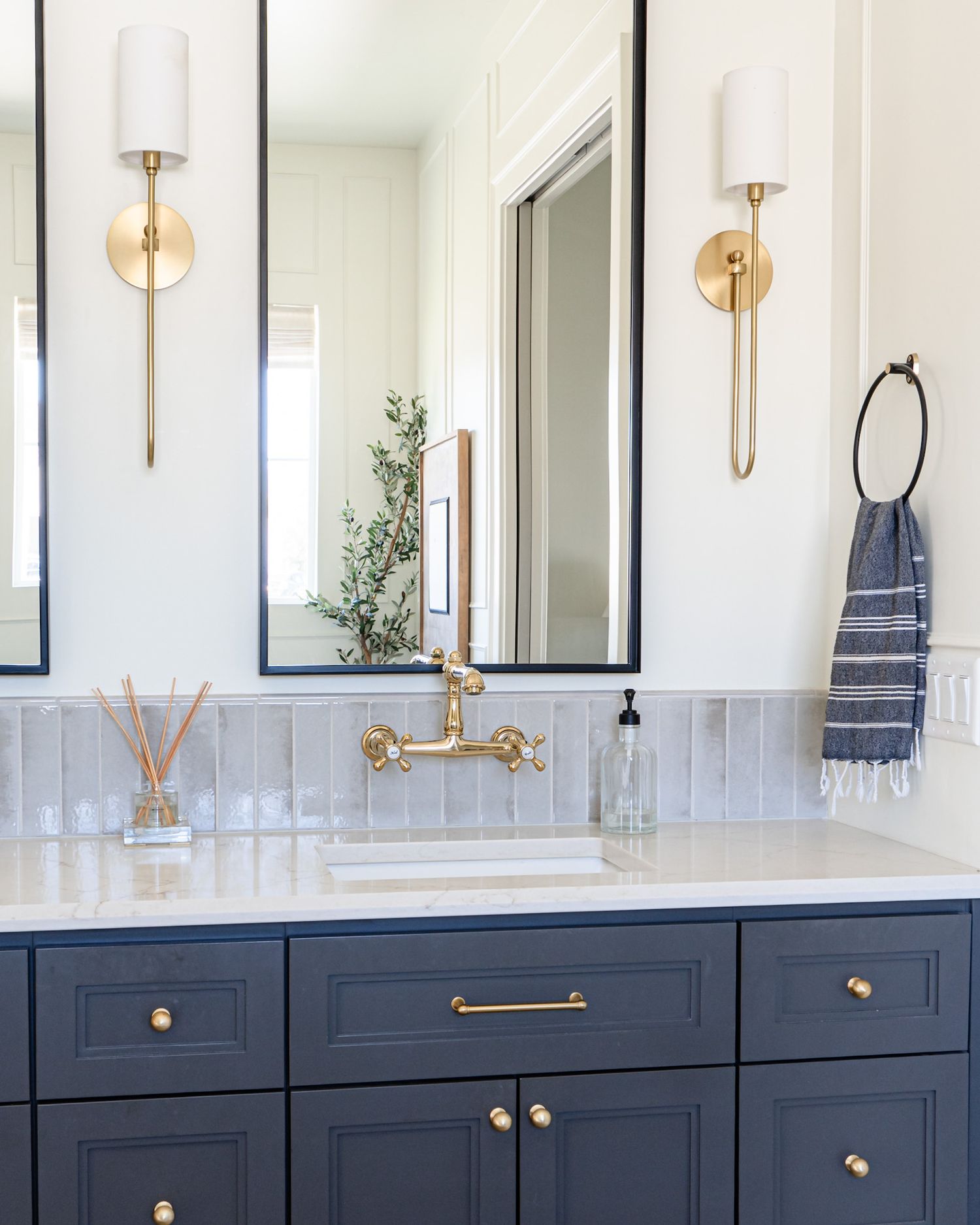 Custom primary bathroom vanity with gold hardware and navy blue paint color.